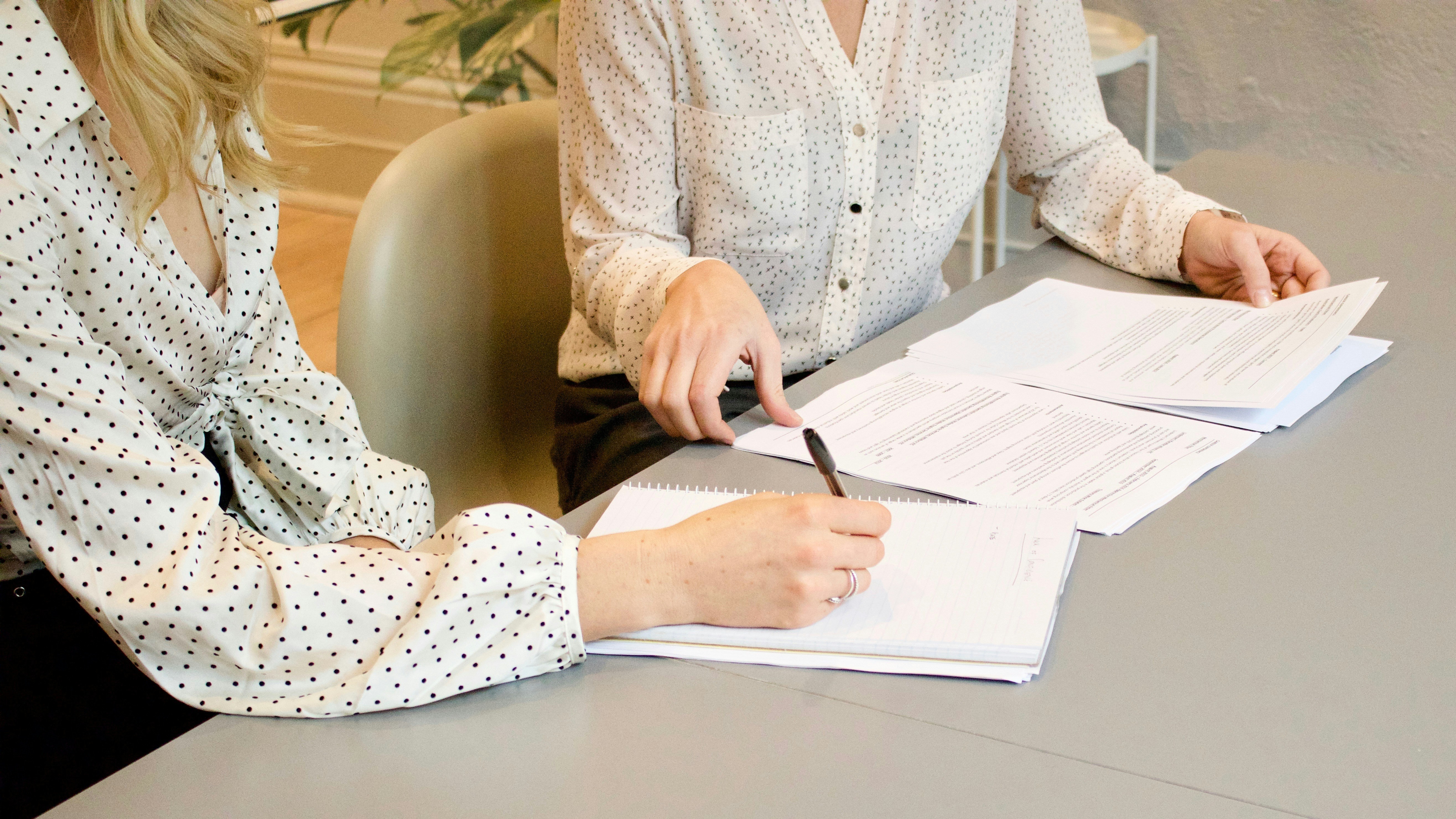Two people reading through documents