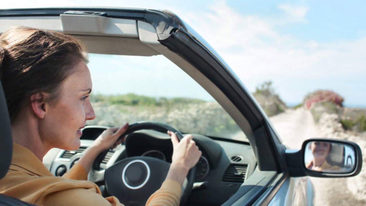Person driving a car with the roof down