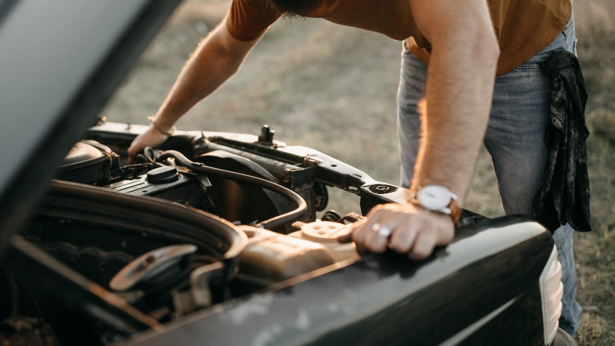 Person looking into car bonnet