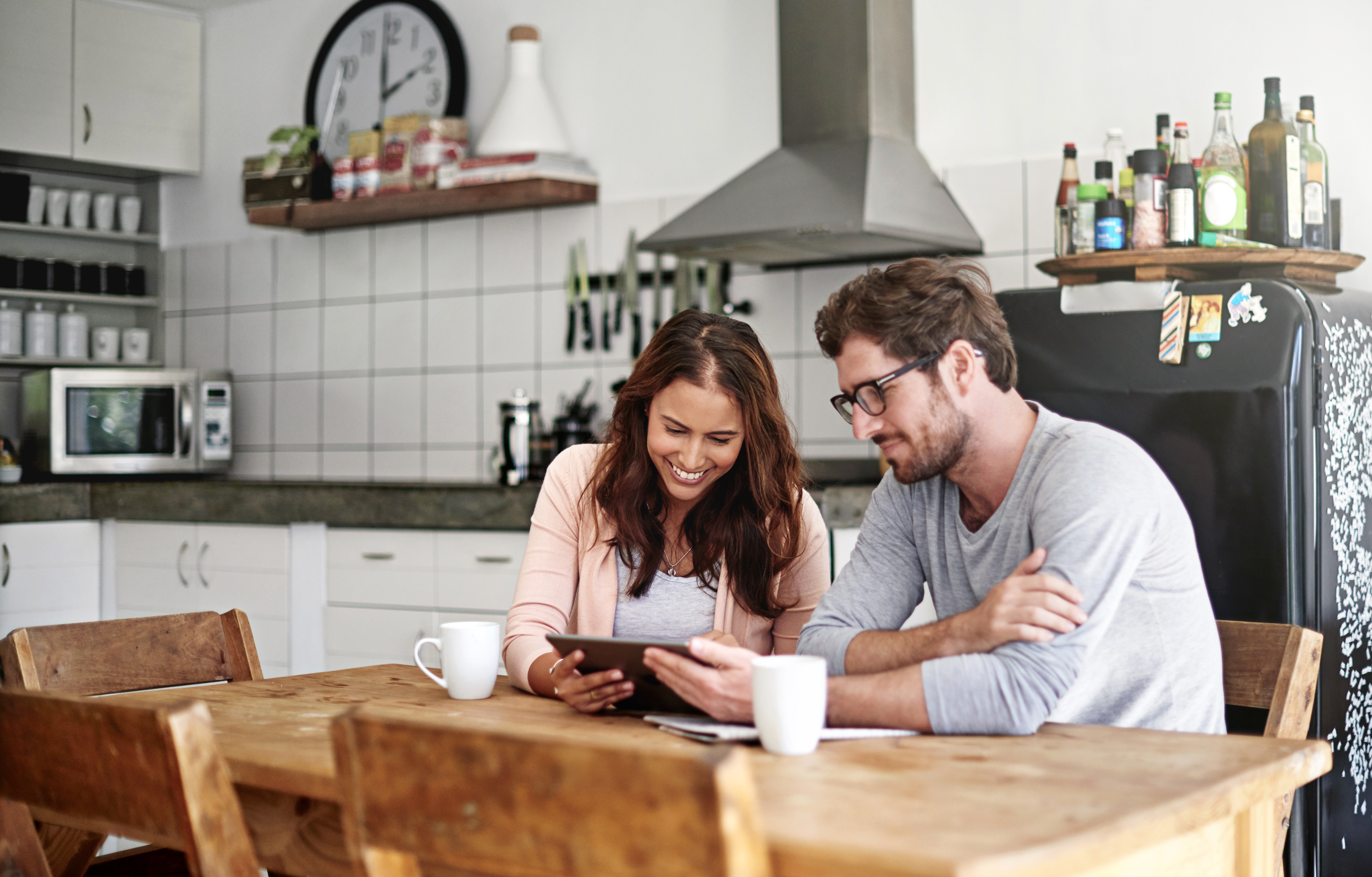 Couple in kitchen looking at tablet