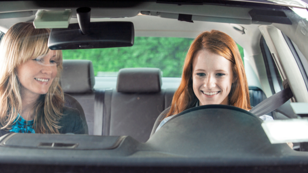 Two people sat in the front of a car