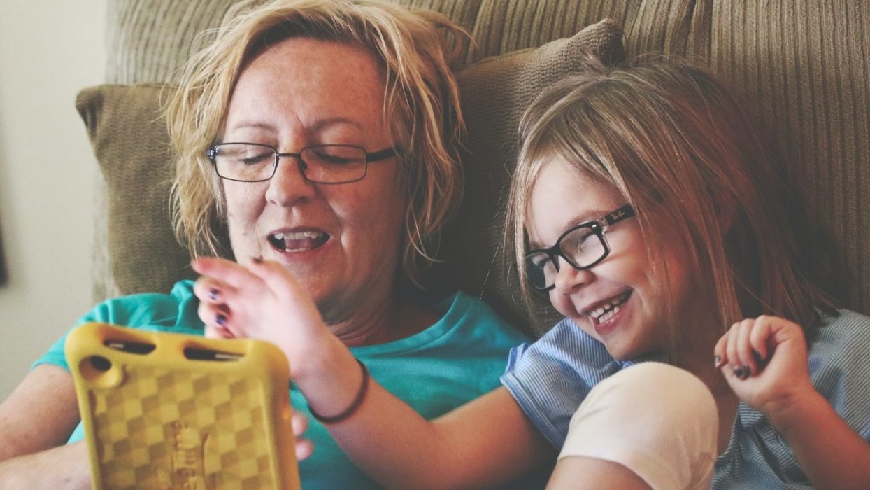 Mother and daughter laughing on sofa