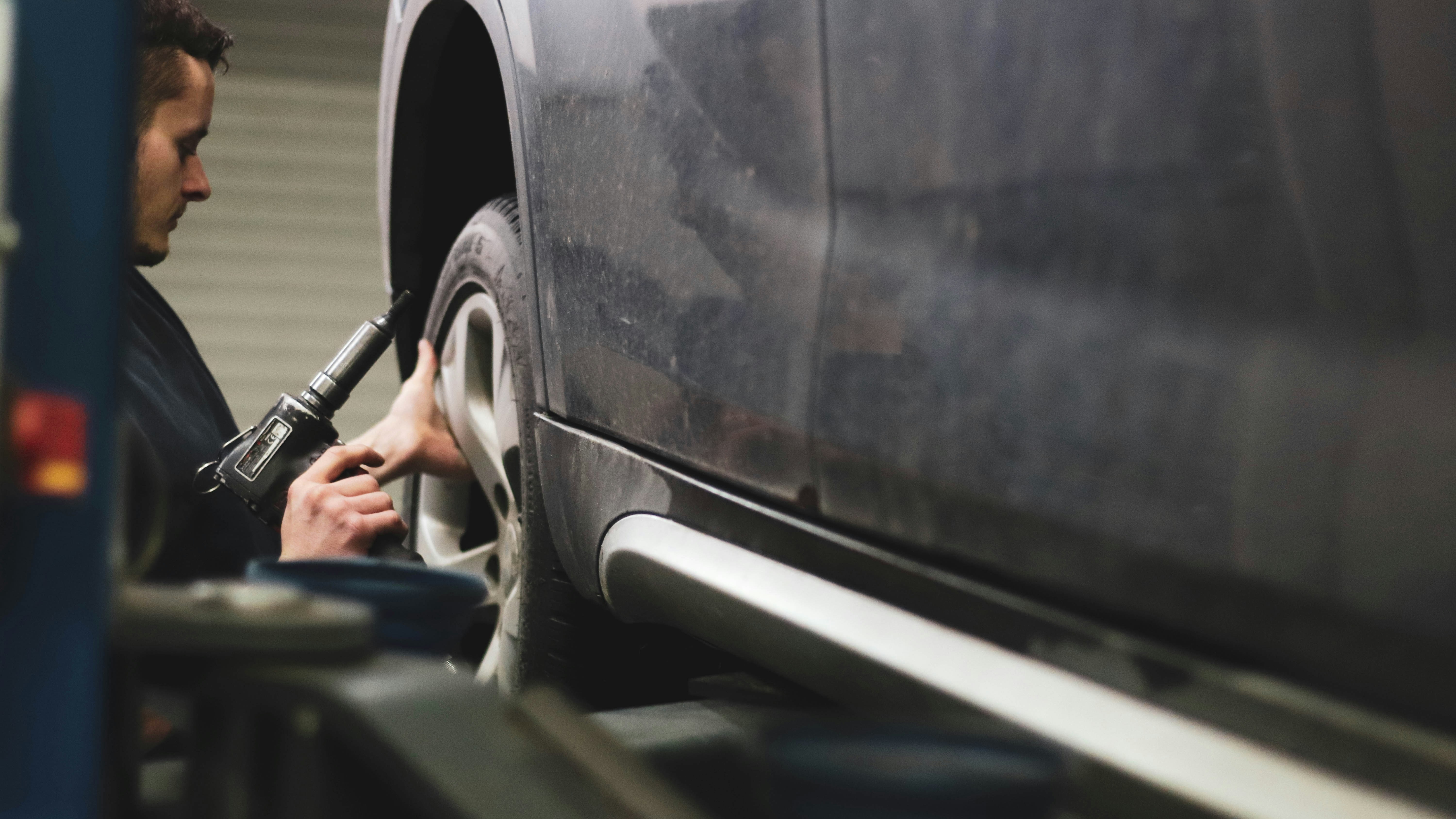 Person checking the tyres on a car