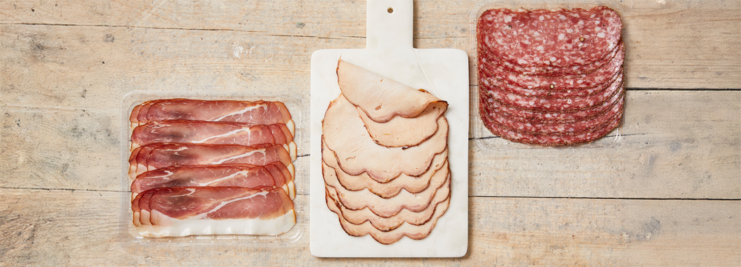Drie soorten vleeswaren van PLUS Puur van Smaak: prosciutto, kalkoenfilet, en salami.