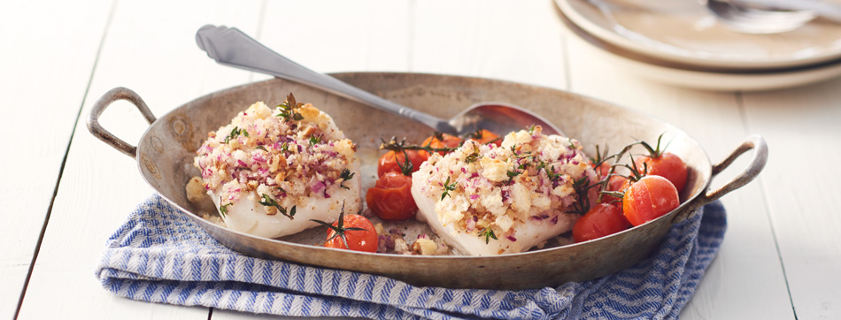 Skrei-vis en recept, omringd door verse ingrediënten zoals citroen, kruiden en groenten.