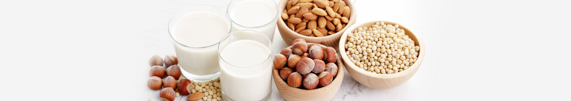 Lactosevrij: verschillende noten en zaden met glazen plantaardige melk, zoals amandel-, hazelnoot- en sojamelk.