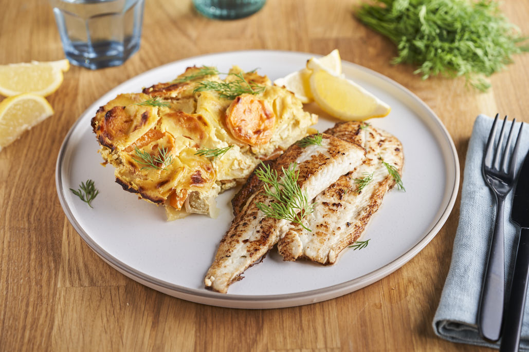 Gebakken scholfilet met aardappelschotel van prei en wortel in mosterdsaus