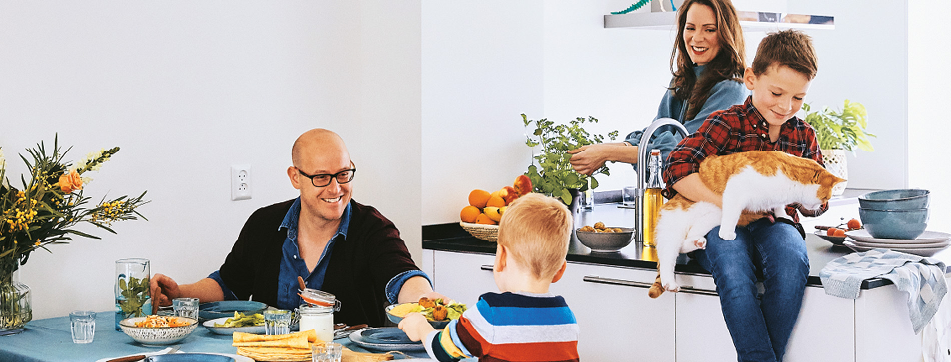 Gezin in de keuken met PLUS producten.