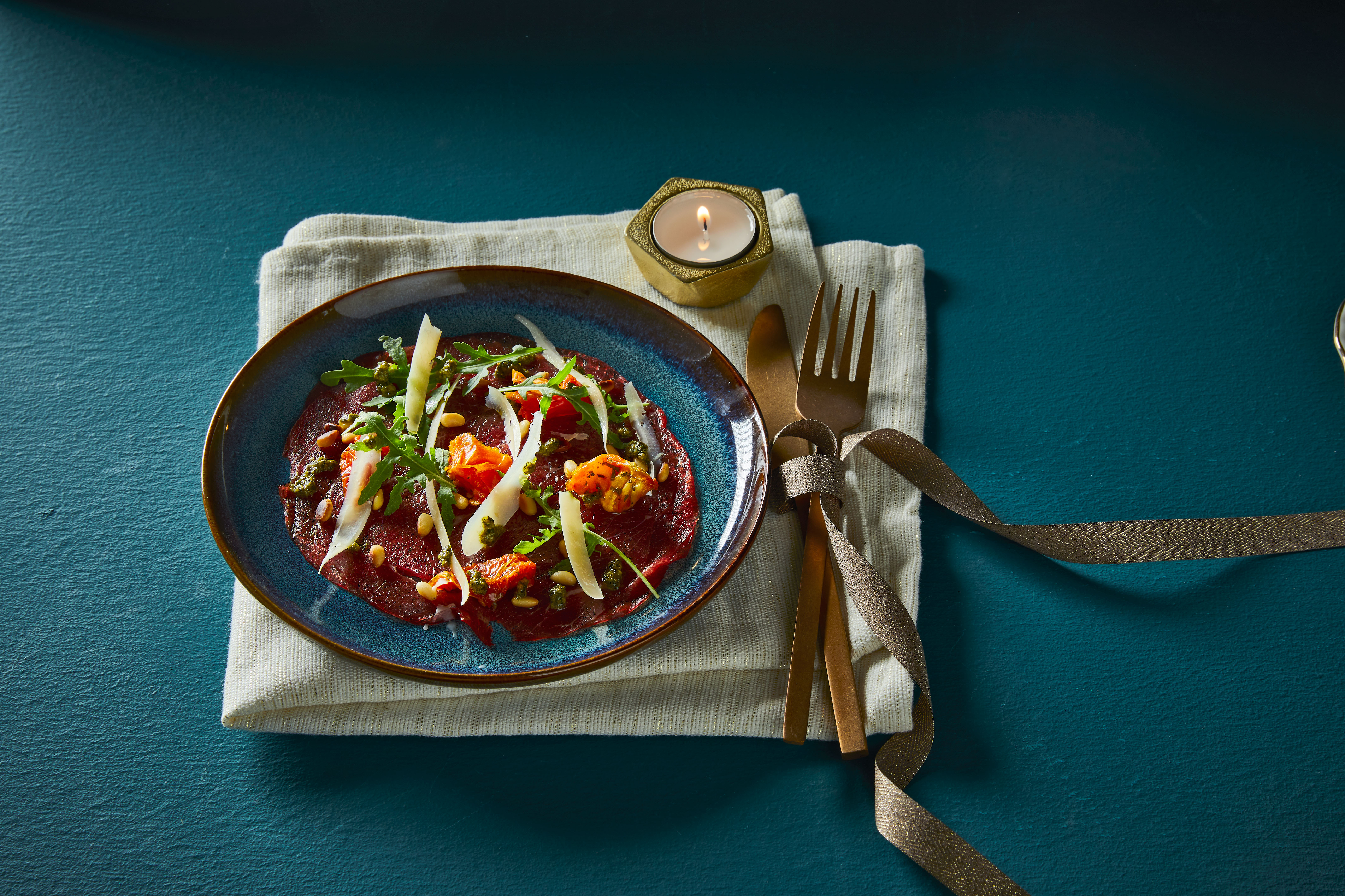 Carpaccio met pestosaus, rucola en zongedroogde tomaatjes