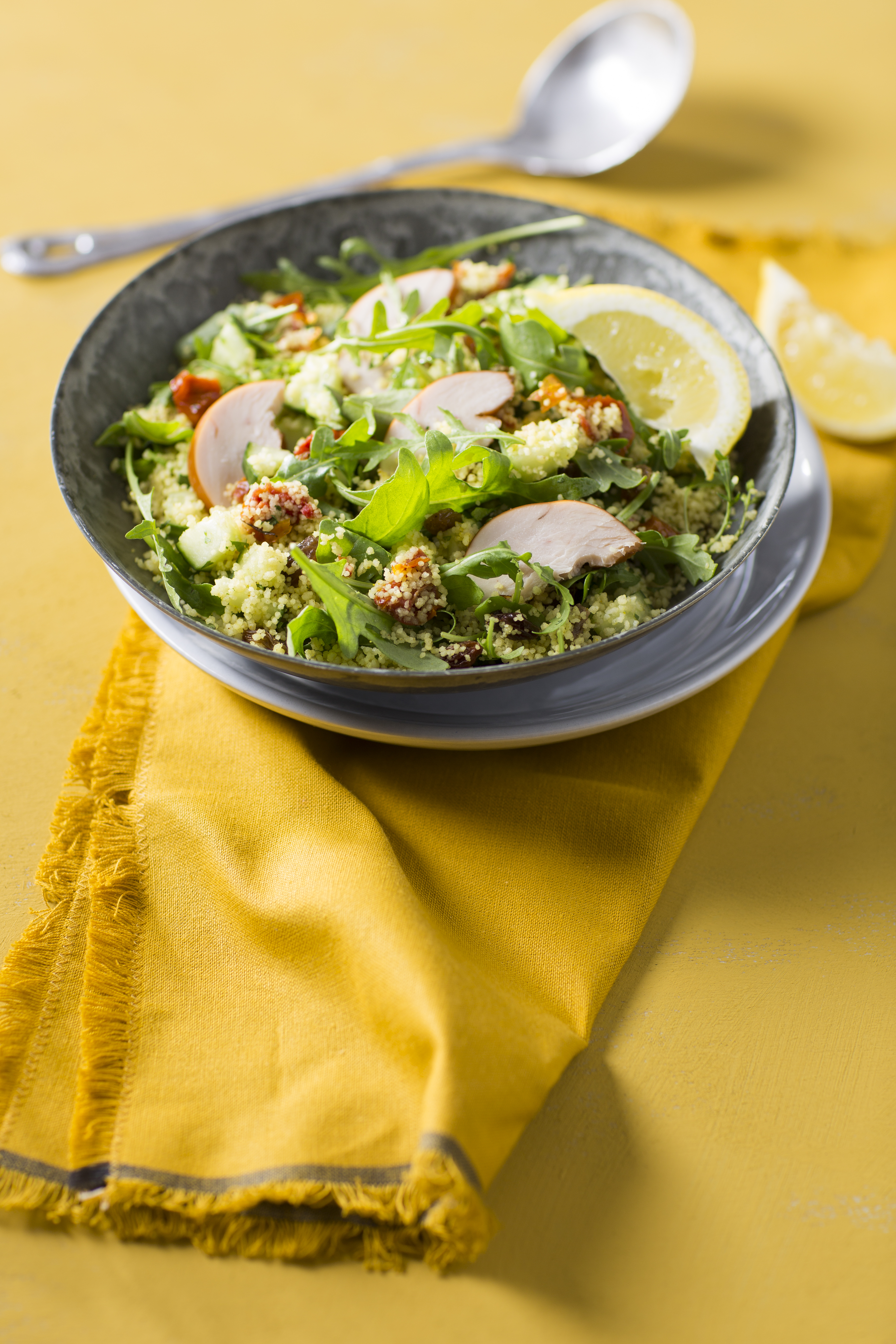 Lauwwarme couscoussalade met rozijnen en gerookte kip