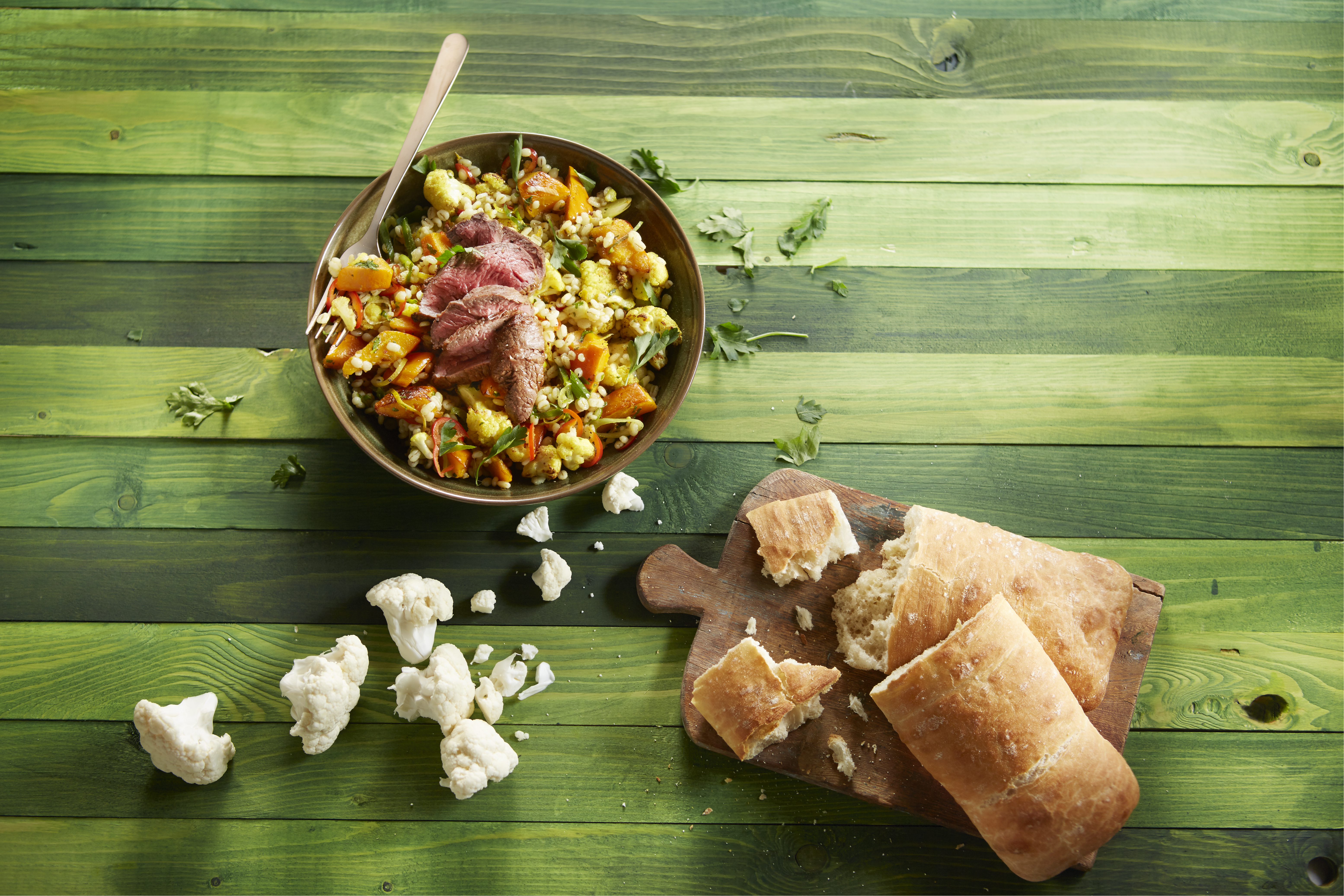 Salade van geroosterde bloemkool en pompoen met parelgort en biefstuk