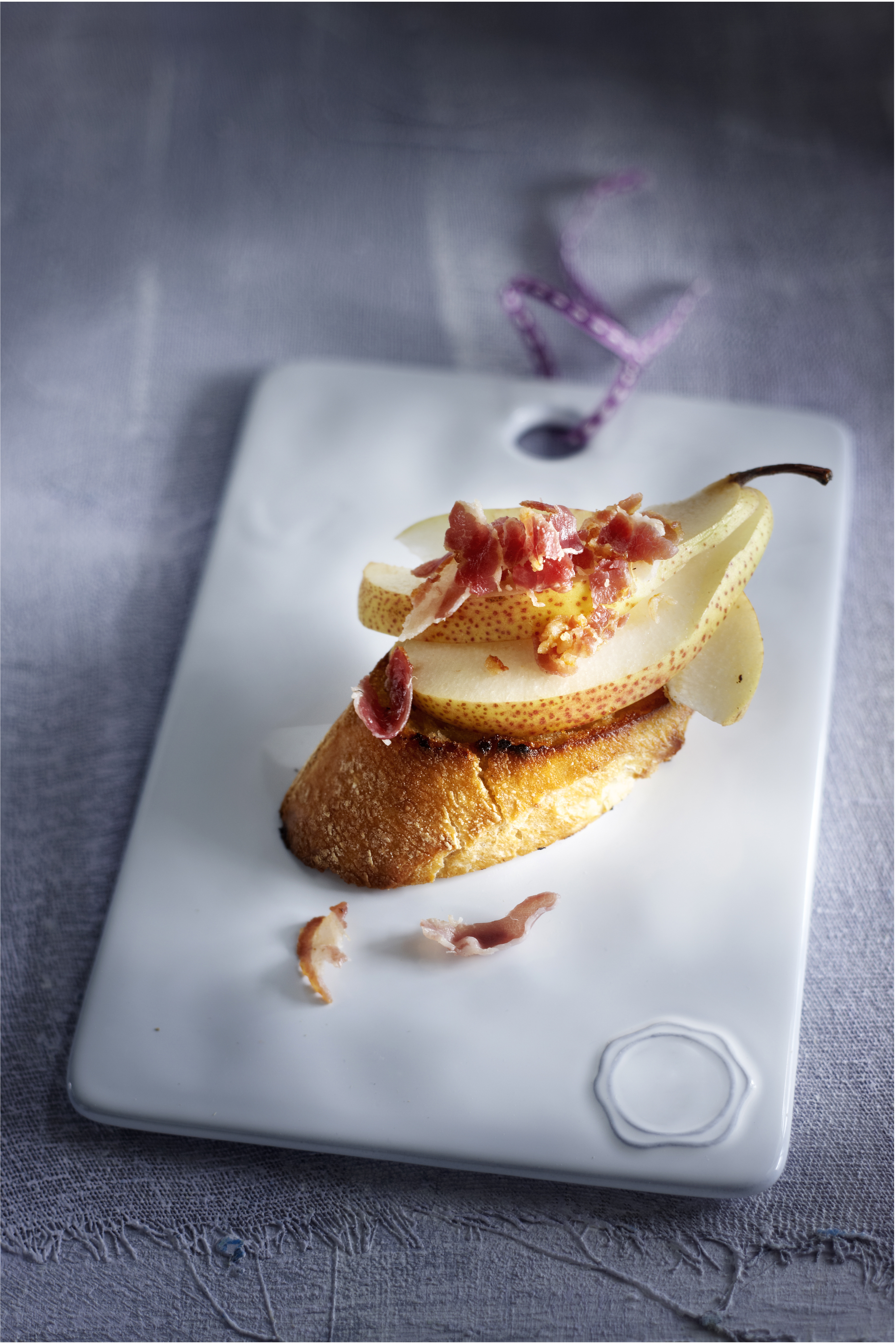 Crostini met olijfolie, peer en pancettakruimels