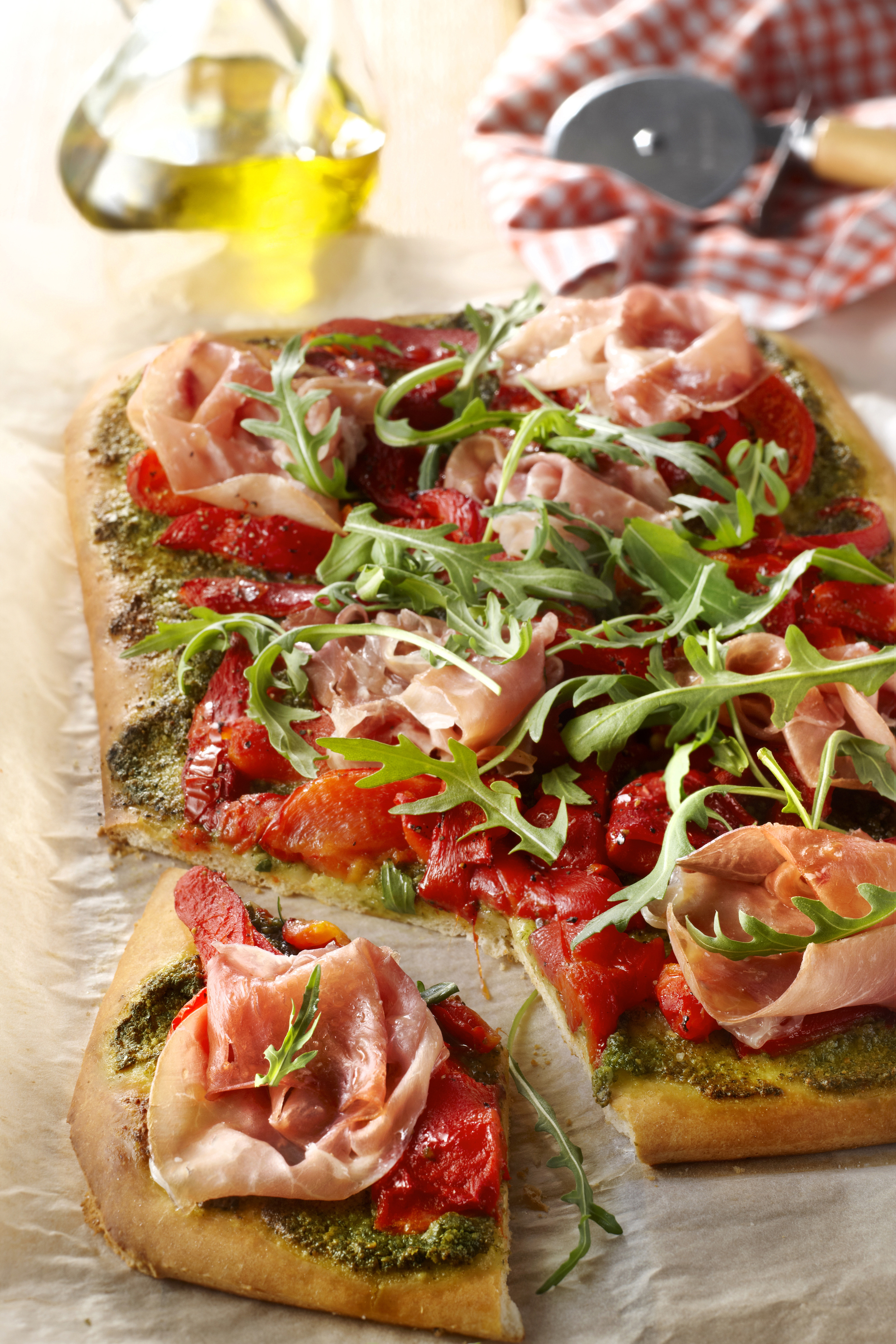 Pizza met rauwe ham, paprika en rucola
