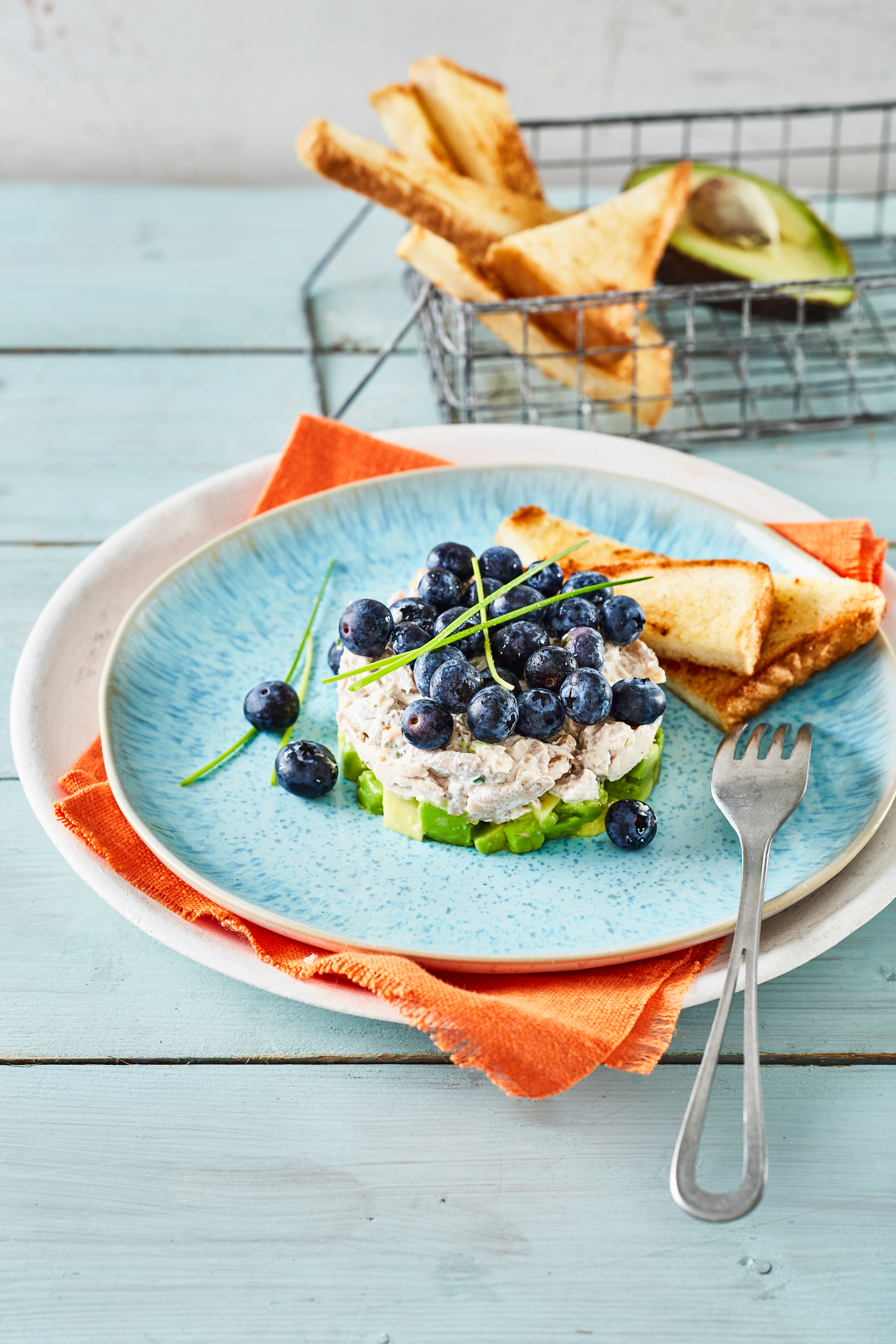 Taartje van gepocheerde kip met avocado en blauwe bessen