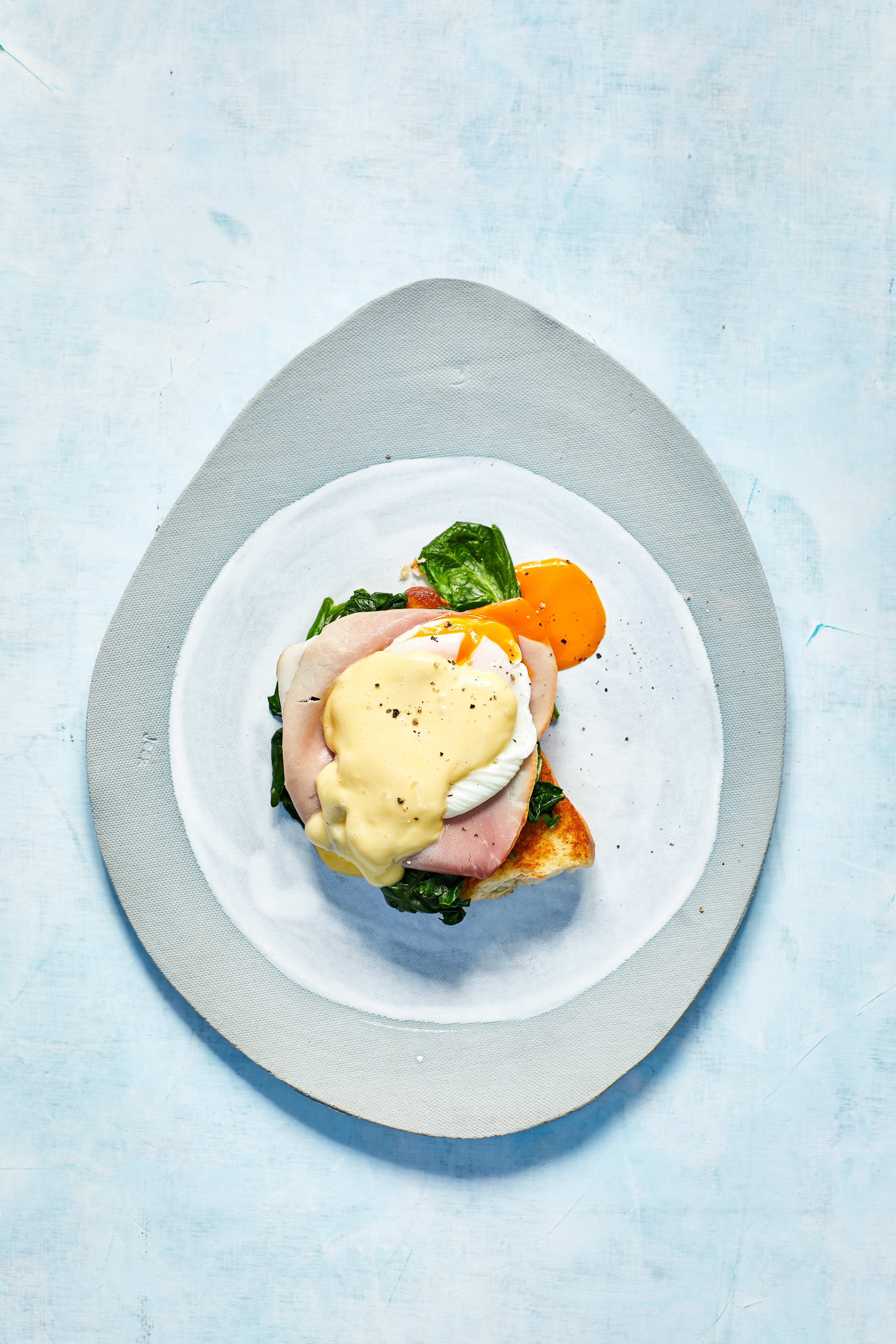 Eggs benedict met ham, spinazie en hollandaisesaus