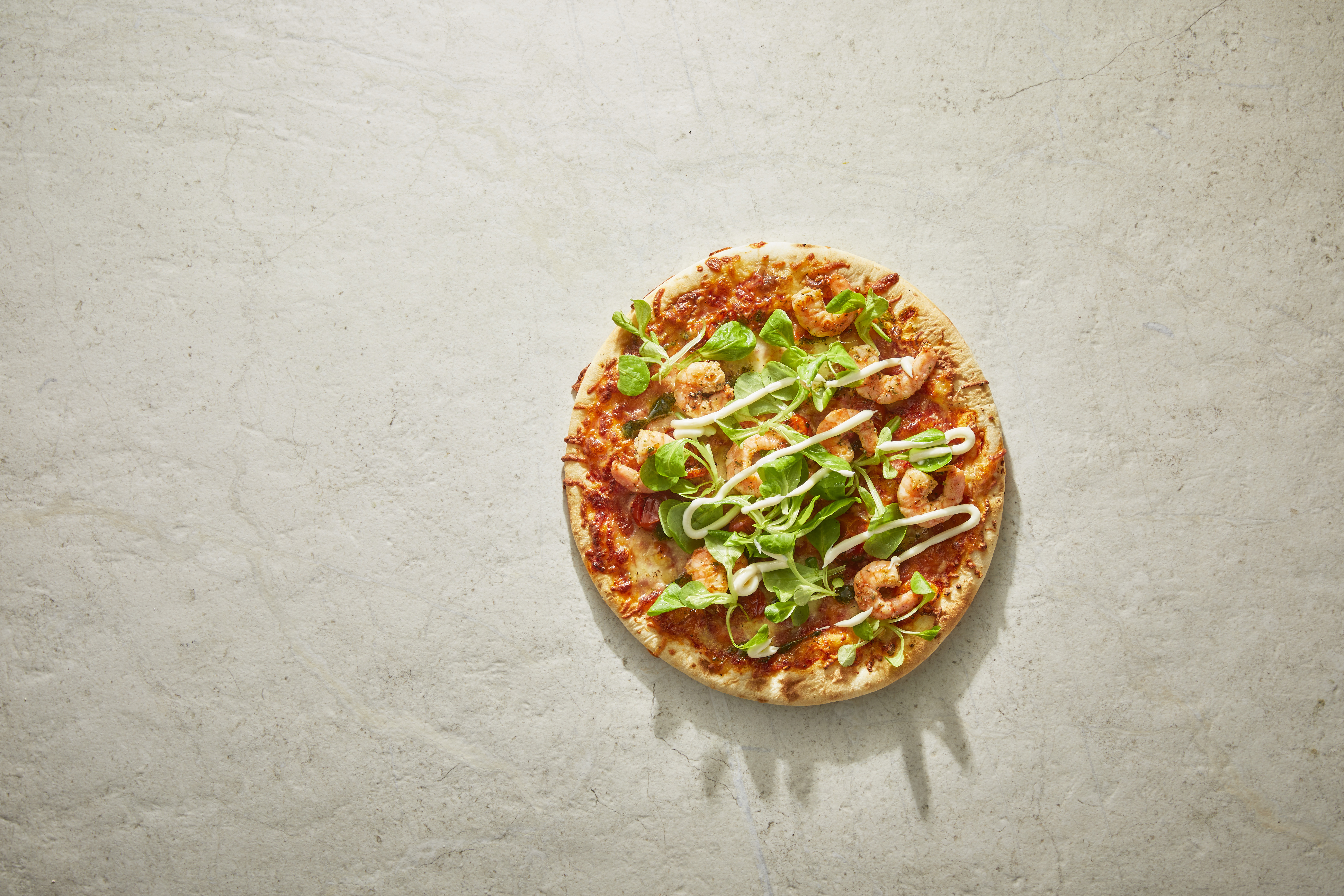 Pizza met veldsla, knoflookgarnalen en aioli