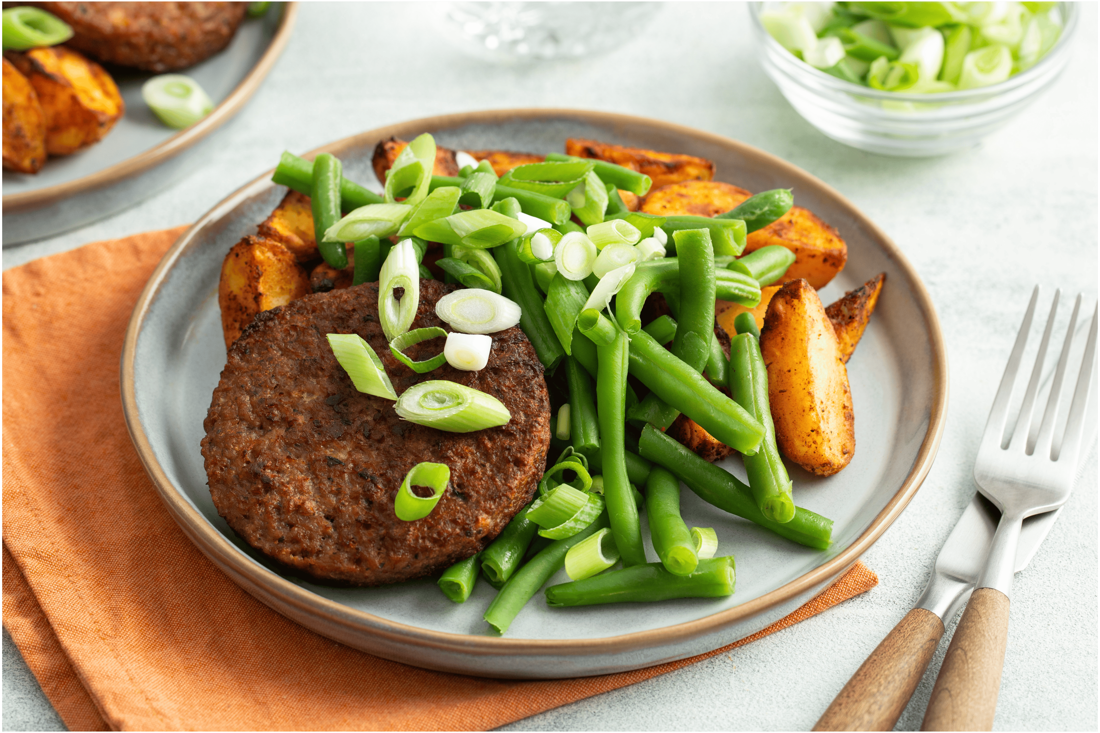 Vegetarische burger met Mexicaans gekruide aardappelen en sperziebonen
