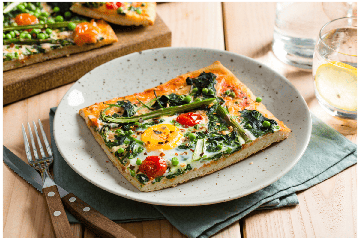Plaatpizza met groene groenten en een eitje