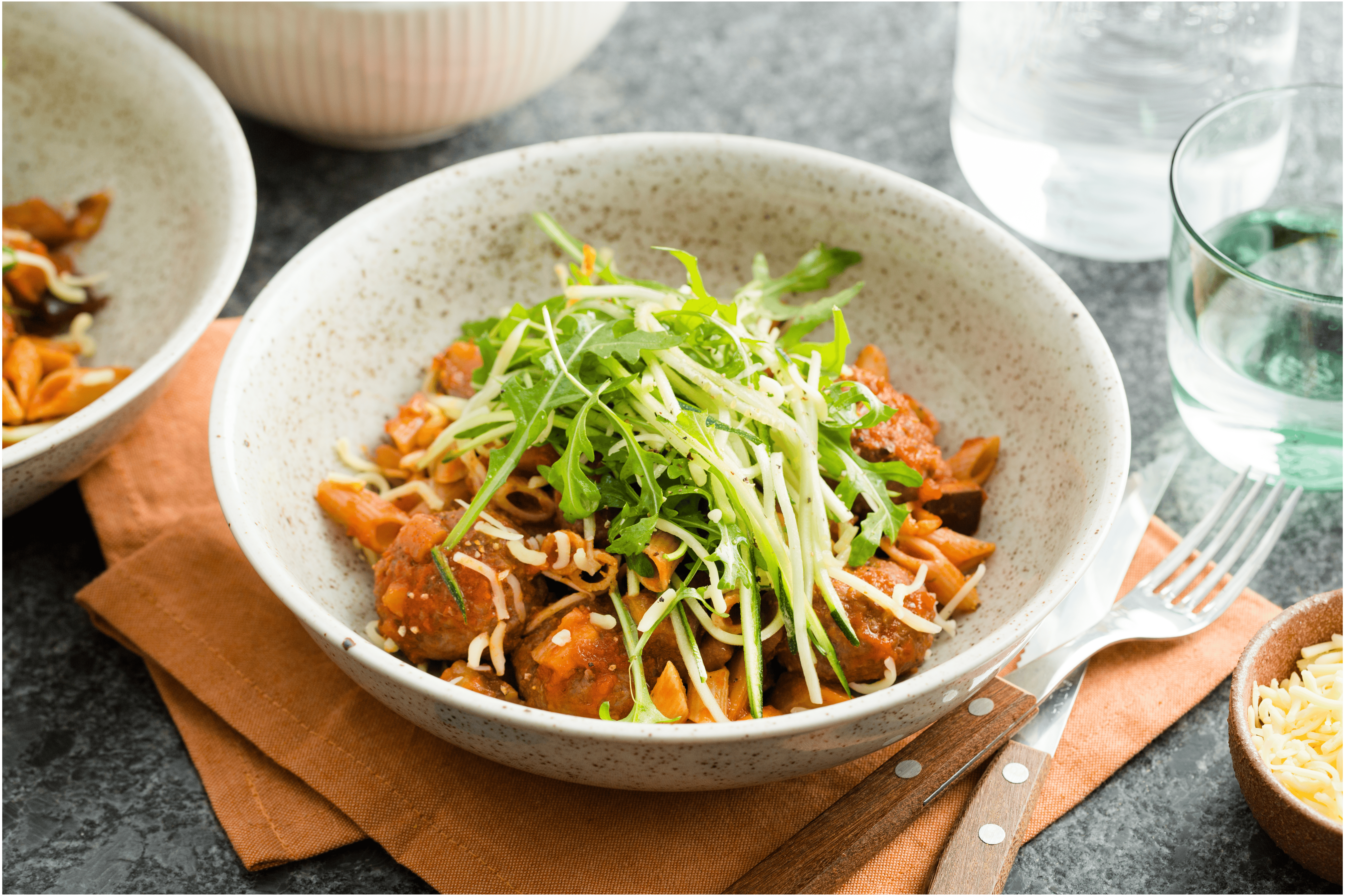 Volkorenpasta met balletjes in tomatensaus en een groene salade