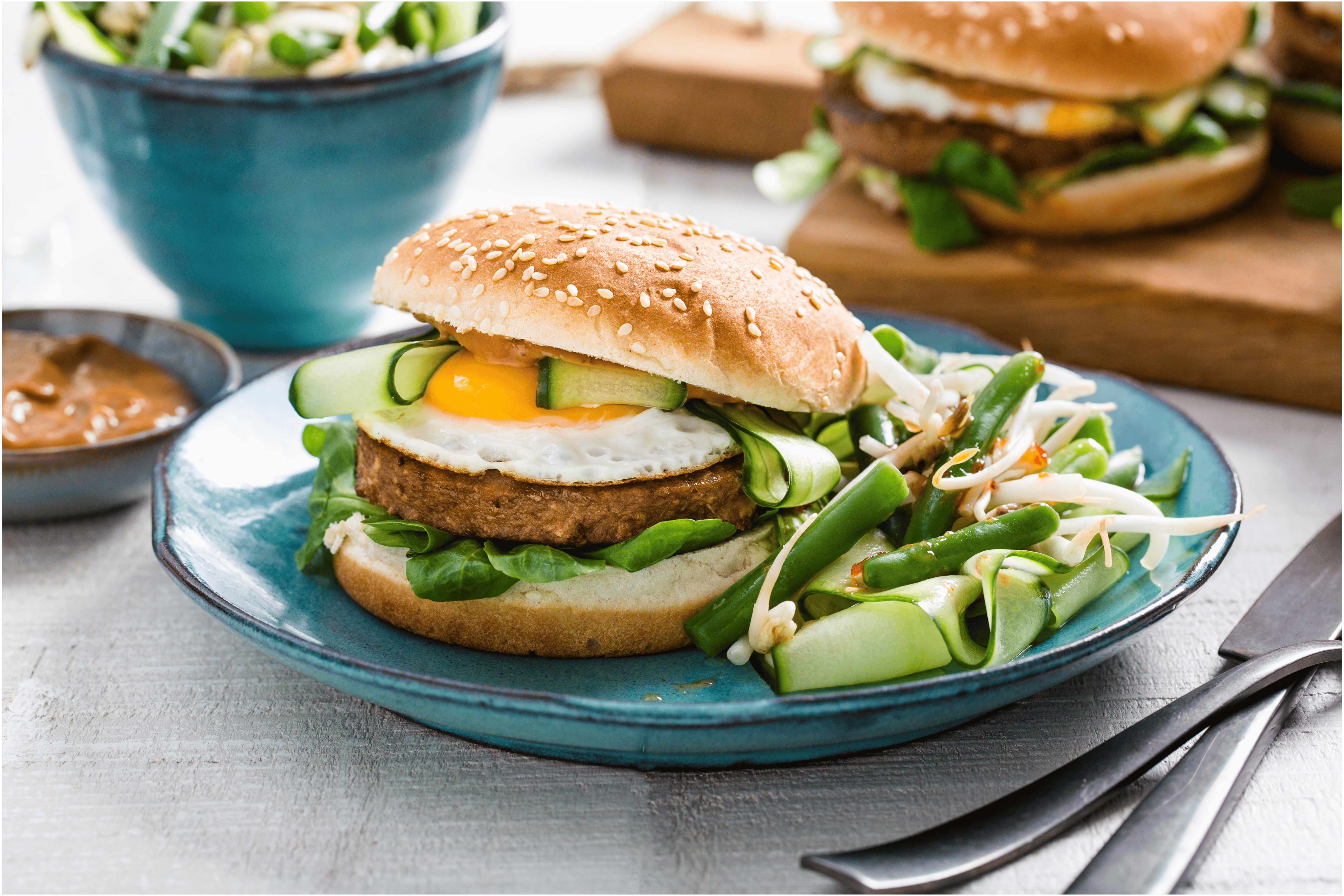 Broodje vegetarische hamburger met sperziebonensalade en satésaus