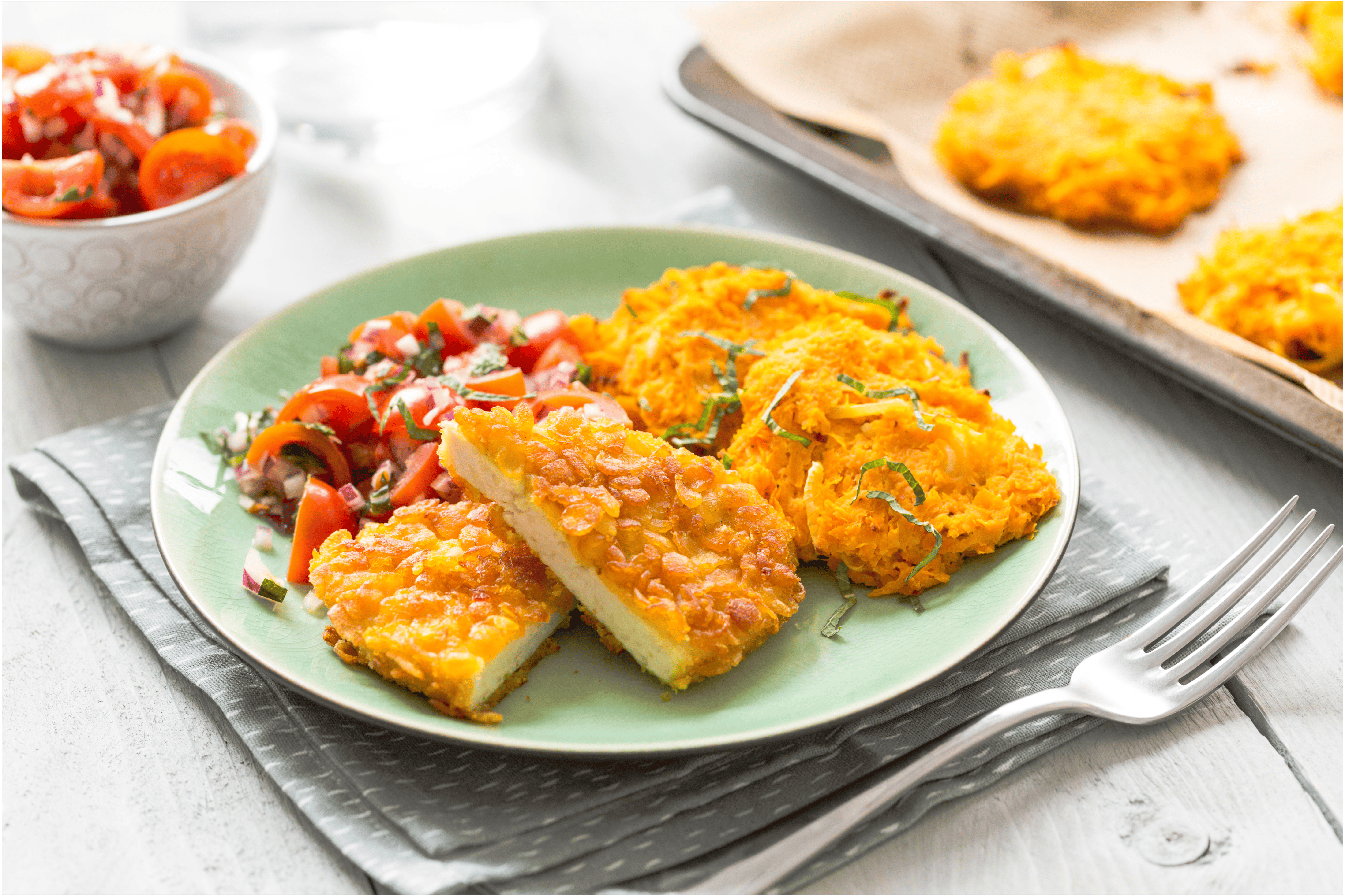 Kipschnitzels met zoete aardappelrösti en tomatensalade
