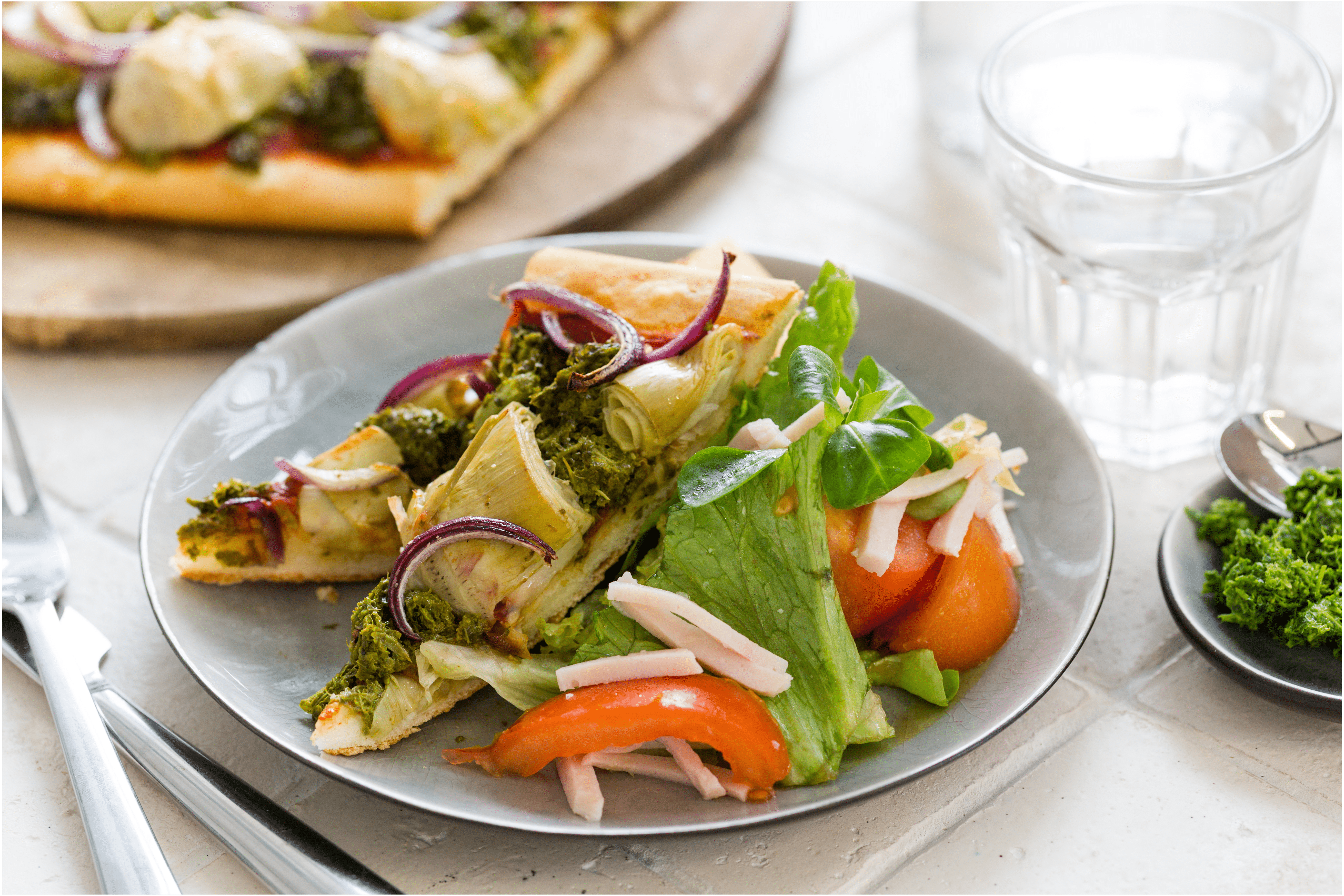 Pizza met boerenkoolpesto, artisjokken en rode ui