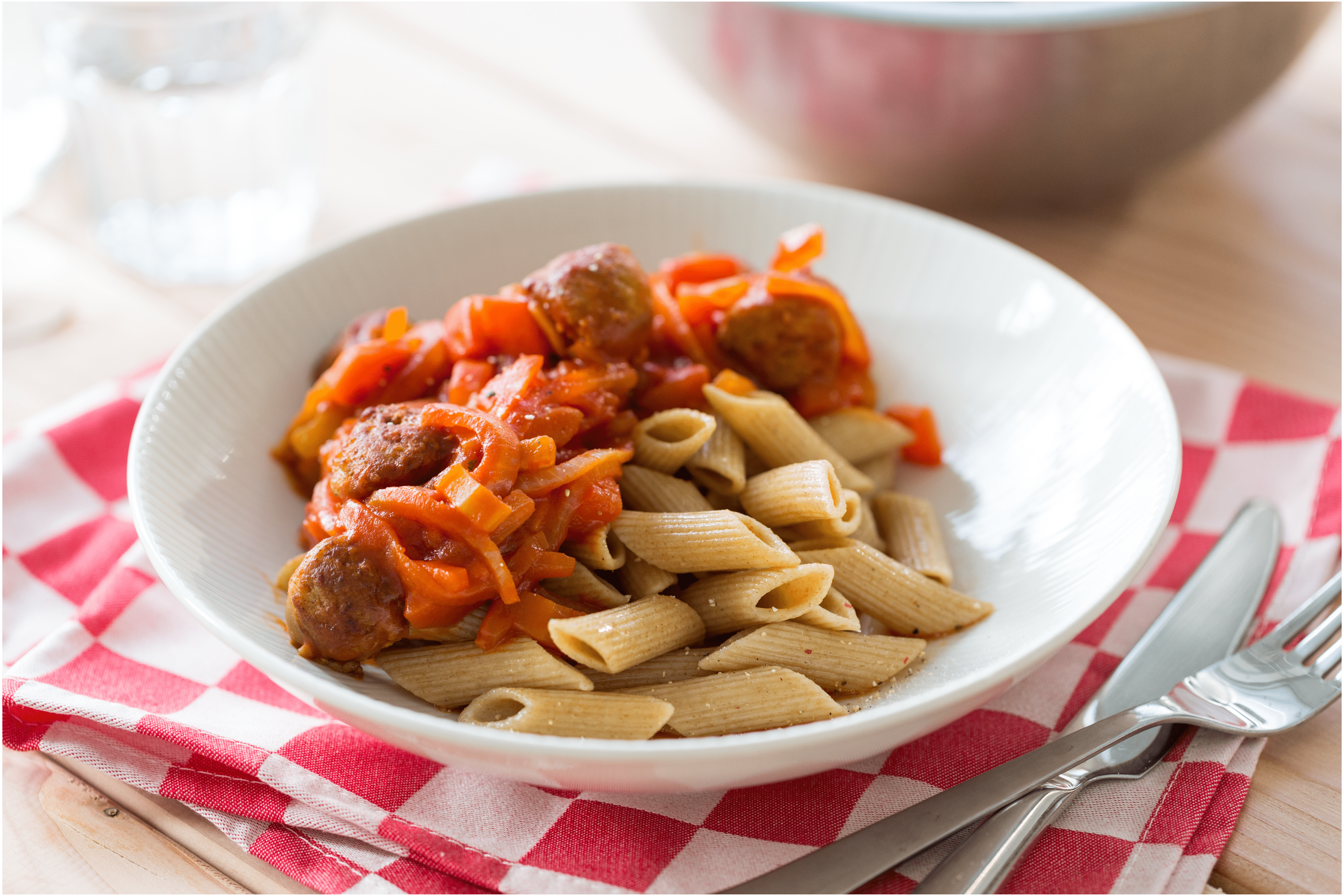 Volkorenpasta met rode saus en saucijzen