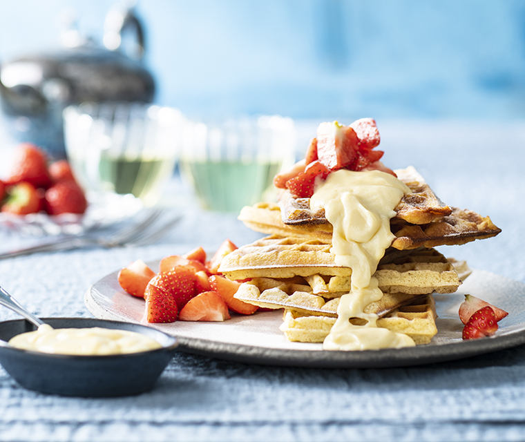 Zelfgemaakte wafels met banketbakkersroom en aardbeien