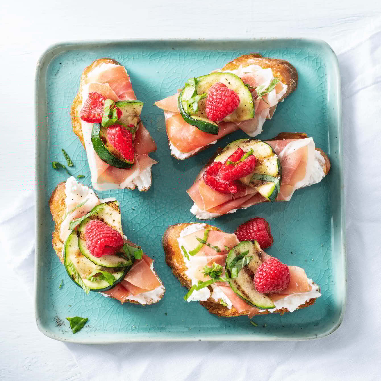 Bruschetta met ham, frambozen, geroosterde courgette