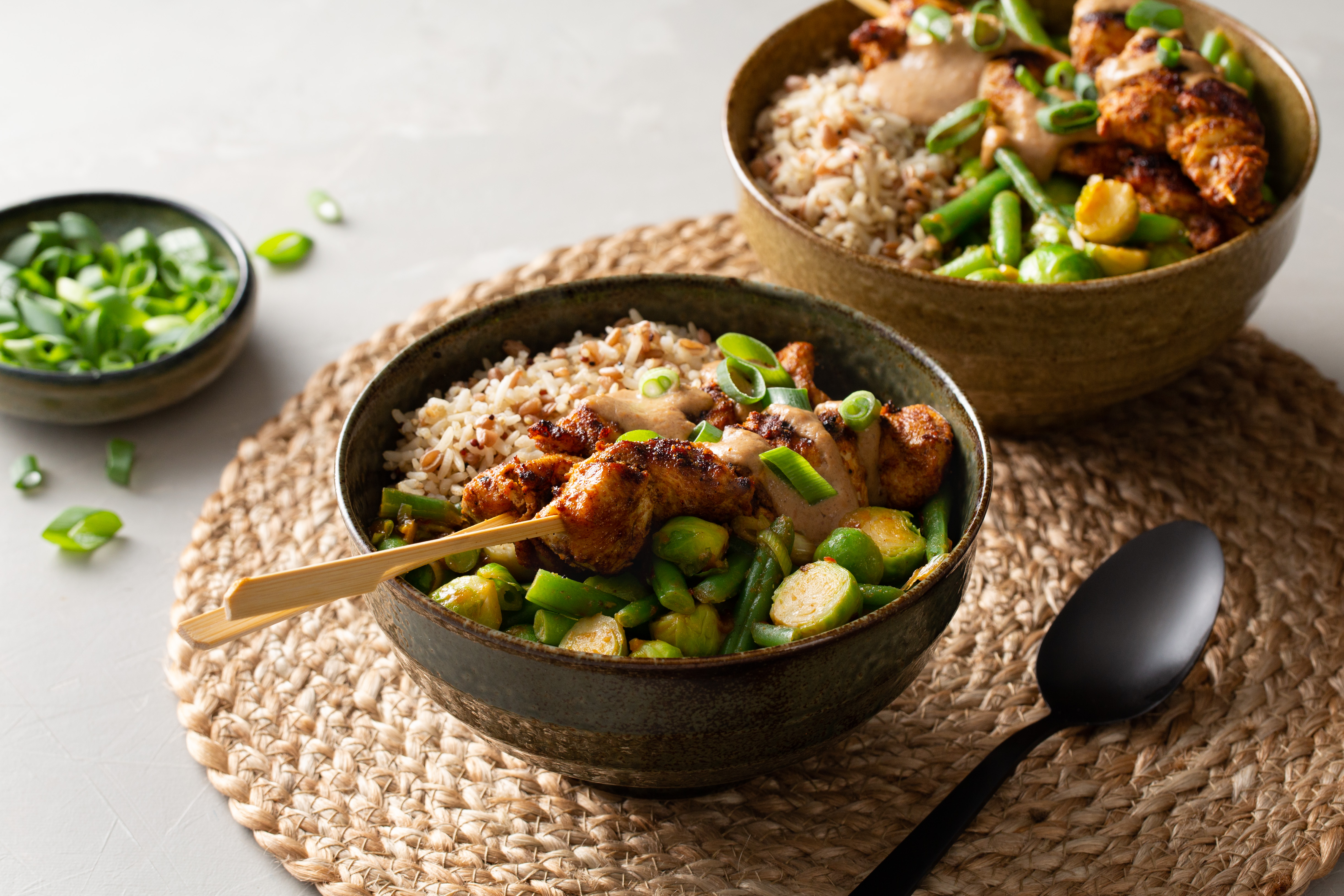 Rijstbowl met groenten in boemboe en kipsaté