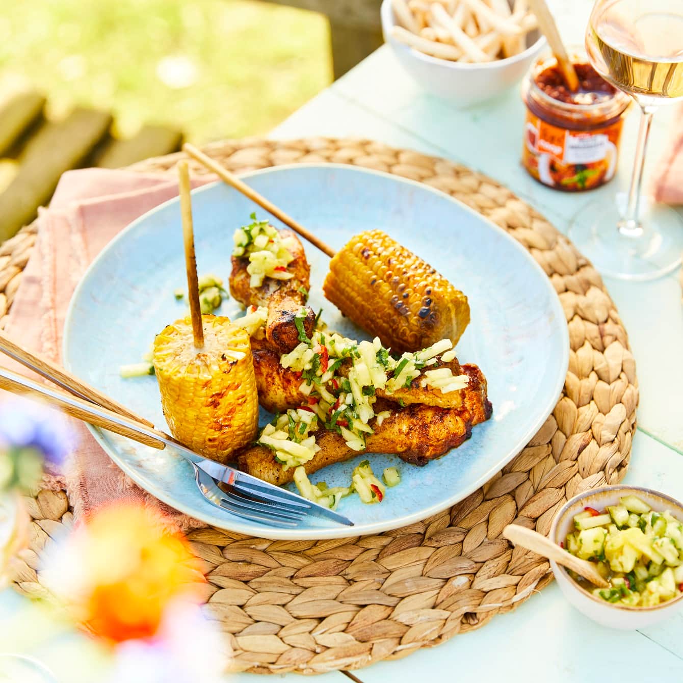 Drumsticks van de barbecue met een tropische ananassalsa en gegrilde maiskolven