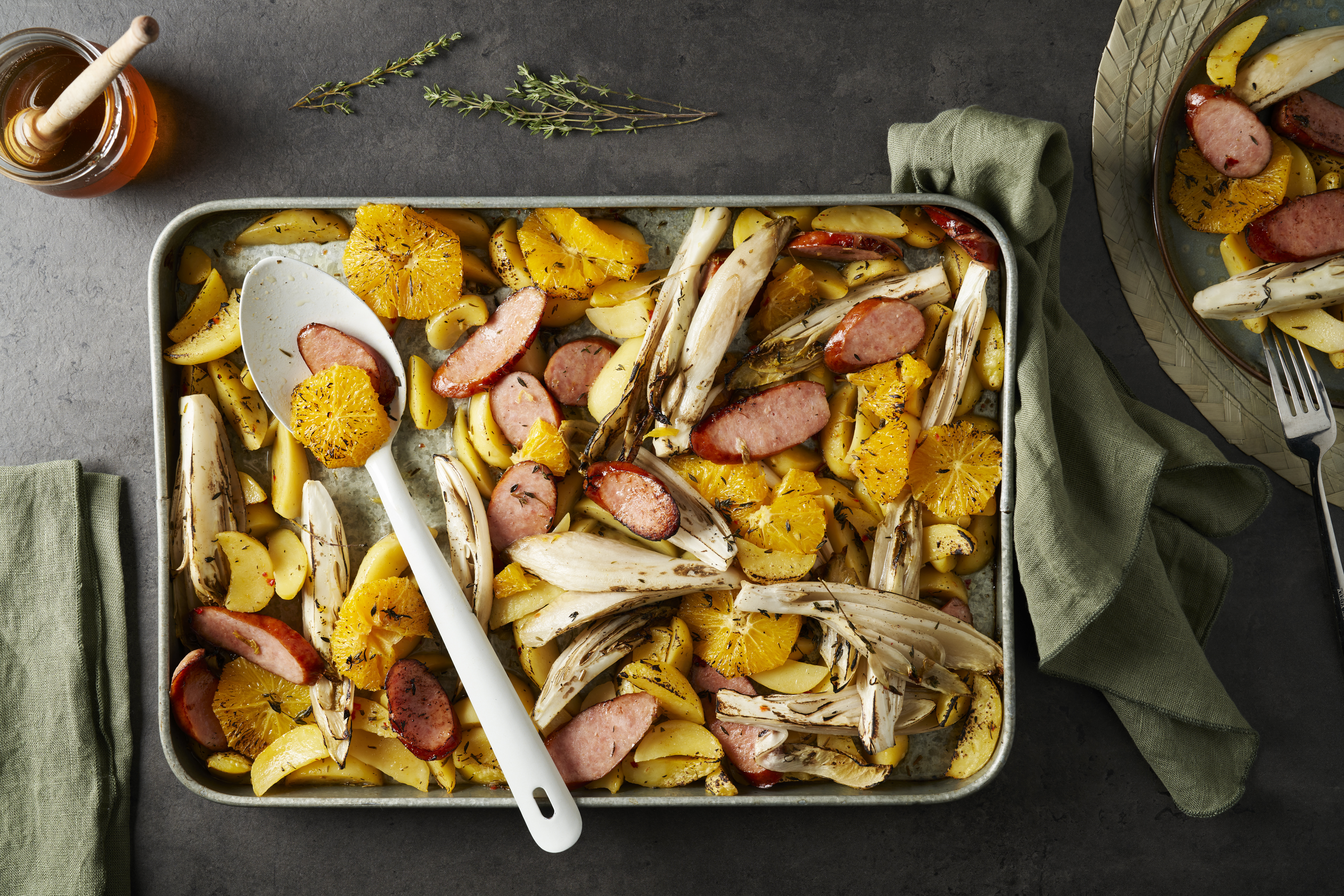 Traybake van witlof, kiprookworst en sinaasappel met knoflookaardappeltjes