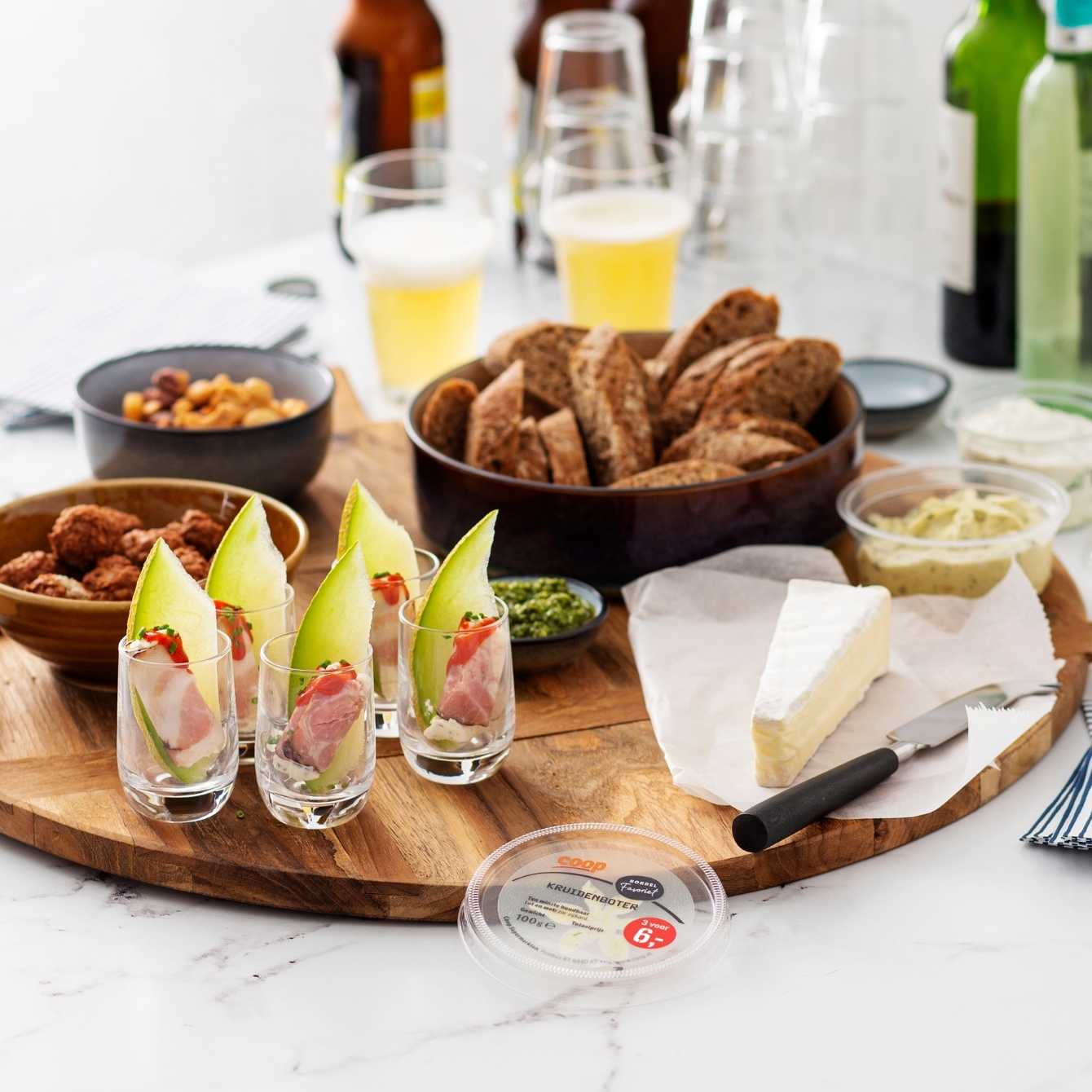 Meloen en Serrano-roomkaasrolletjes in shotglaasjes met hot sauce