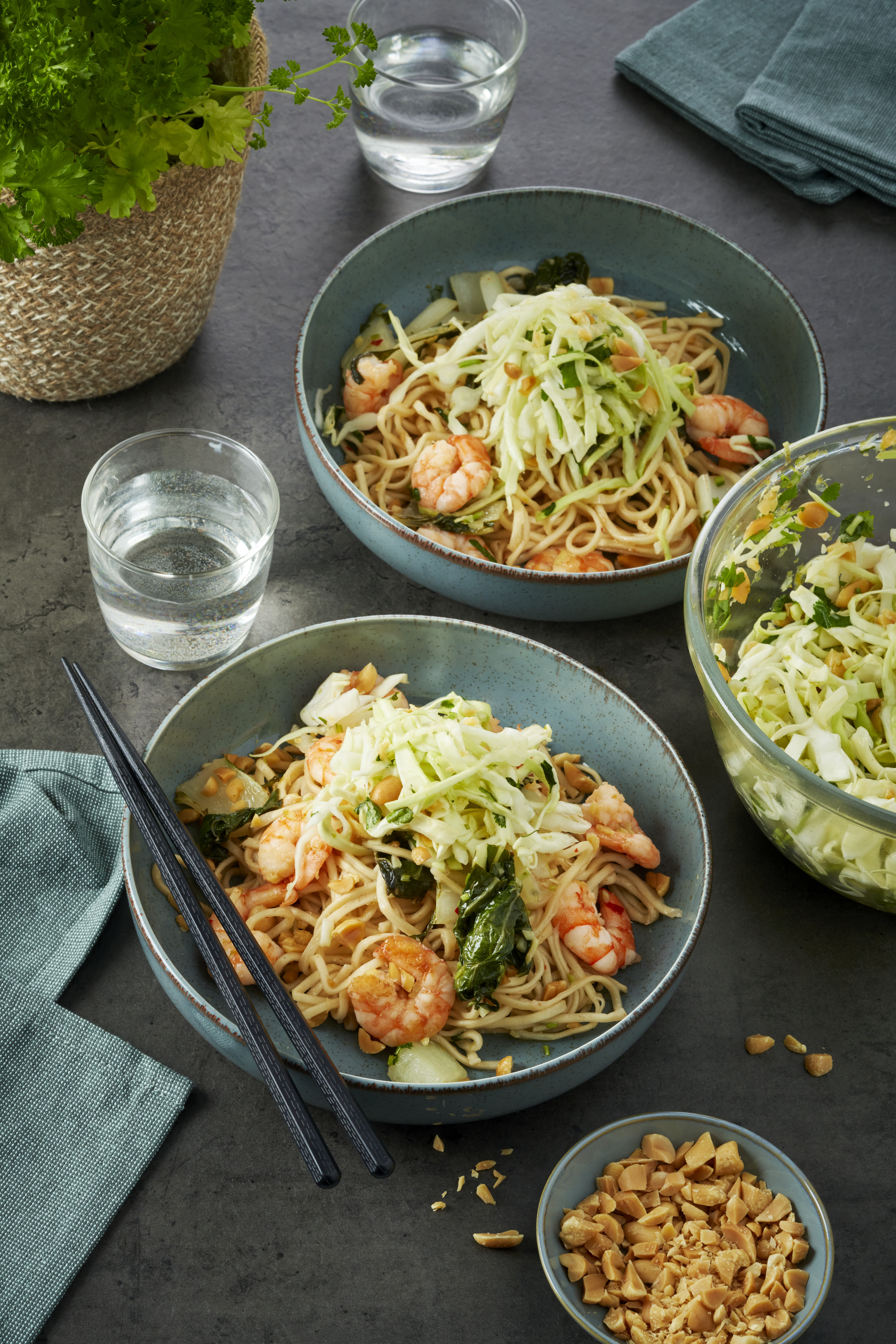 Roerbakschotel van wokgarnalen met eiernoedels en paksoi, met een zoetzure spitskoolsalade