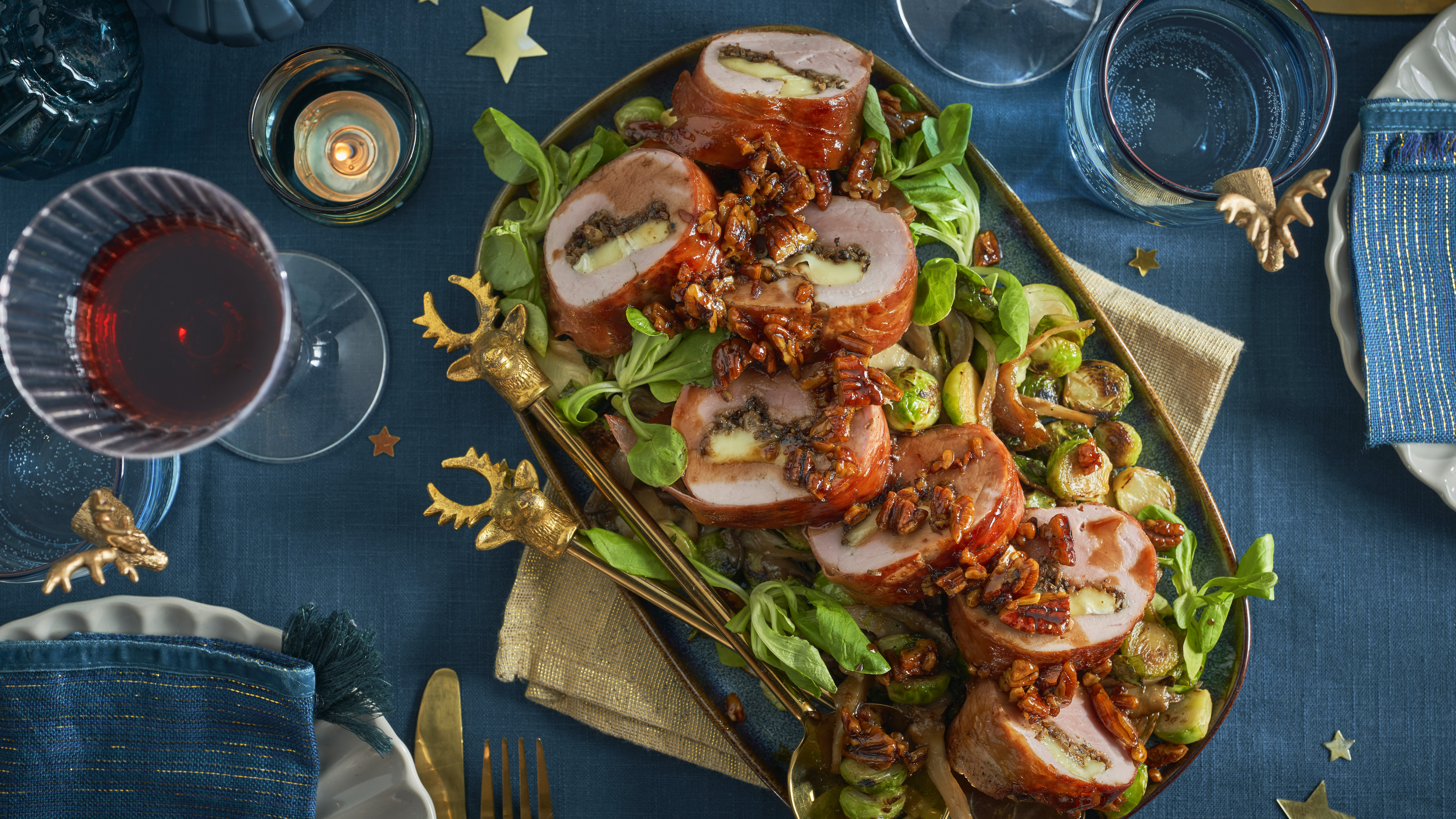 Gevulde varkenshaas met paddenstoelen en brie, geserveerd op een salade van spruitjes