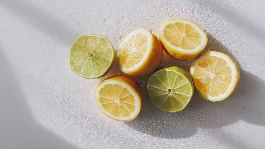 Pile of cut in half lemons and limes on a white background.