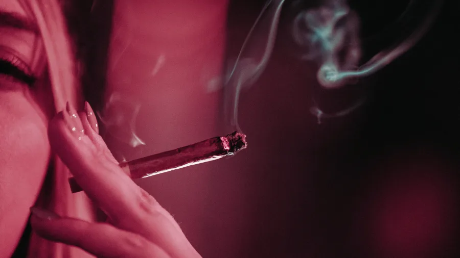 Woman smoking with purple background