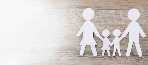 A paper doll family on a wooden table