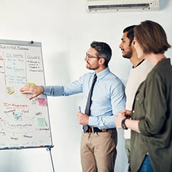 Associates going taking notes on a white board.