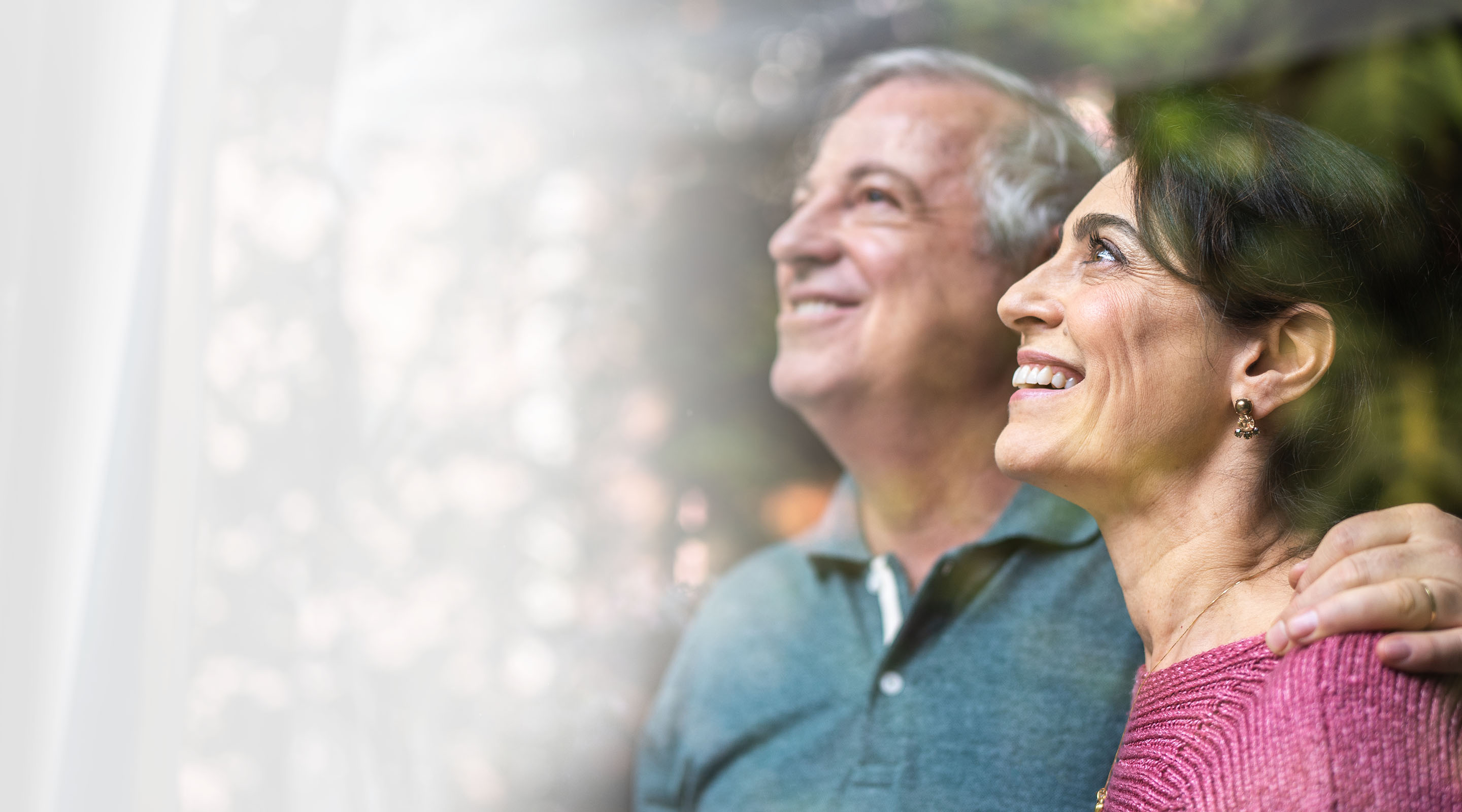 An older white couple peers through the window