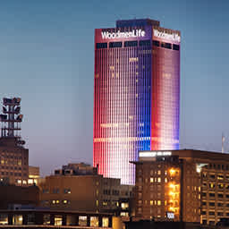 The WoodmenLife tower lit in red, white, and blue.