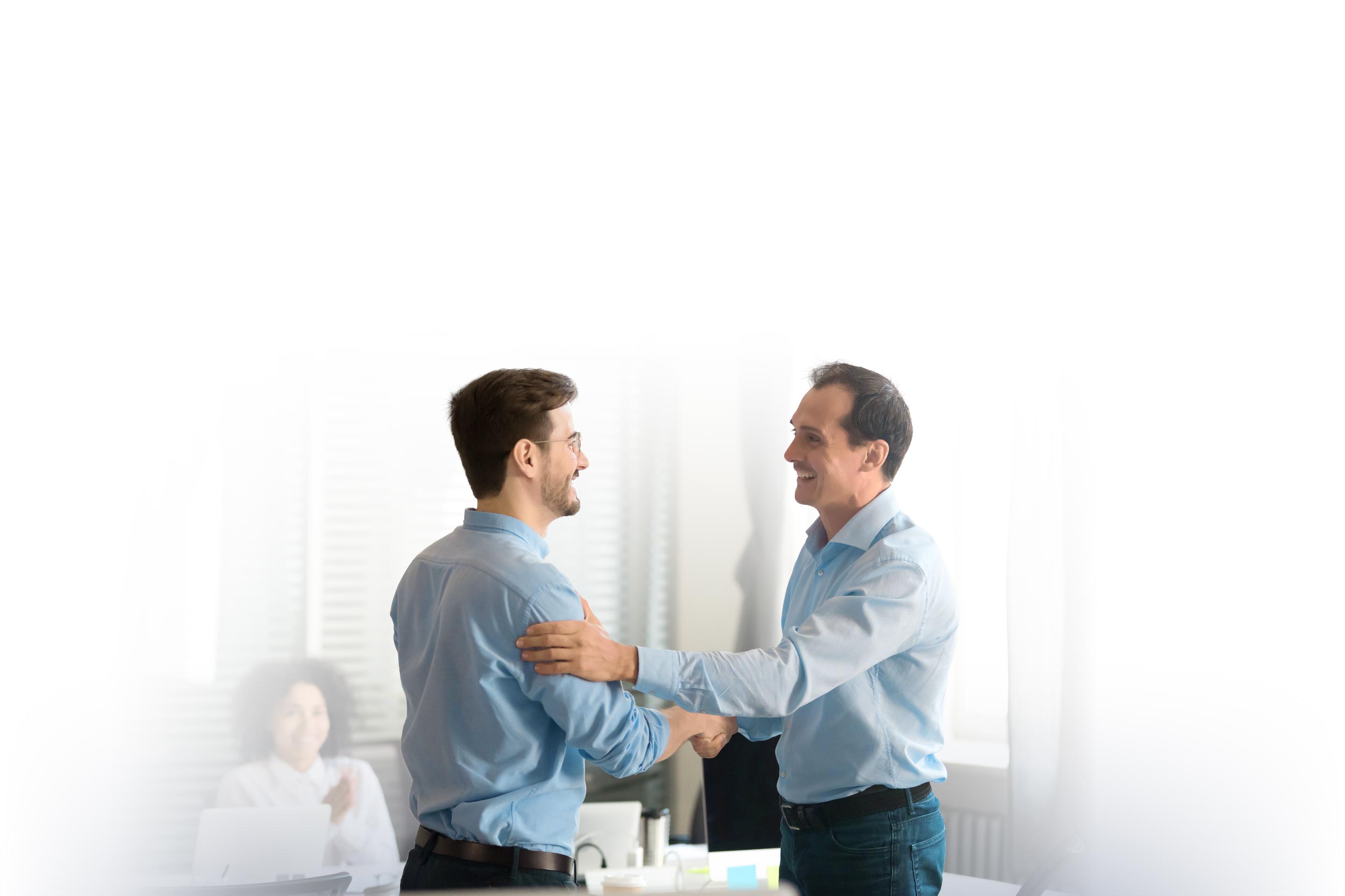 Businessmen shaking hands in a meeting room.