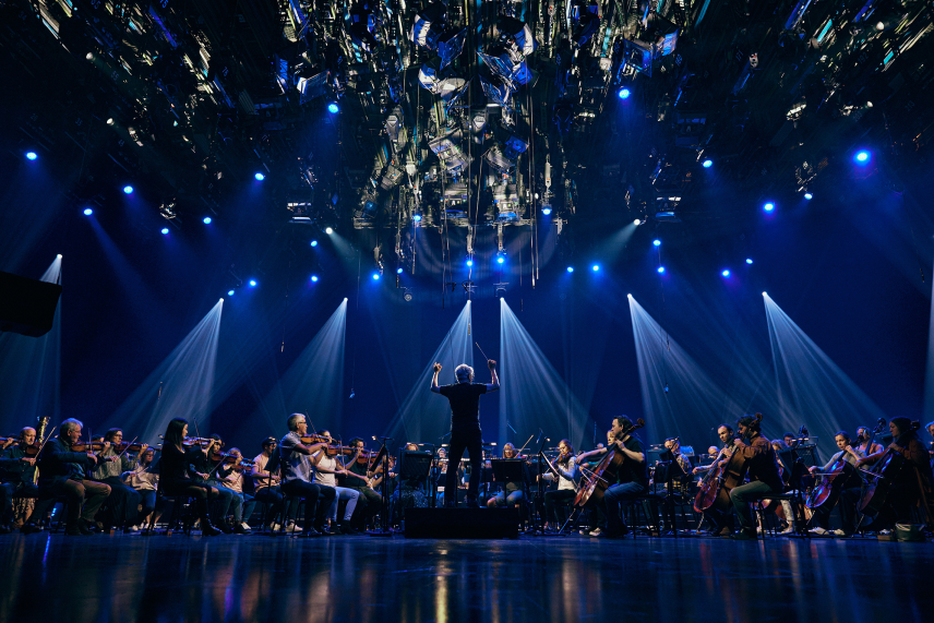 Conductor Peter Breiner leading the Royal Philharmonic Orchestra at the recording of global livestream performances of Igor Stravinsky's The Firebird, Petrushka, and The Rite Of Spring under blue lights