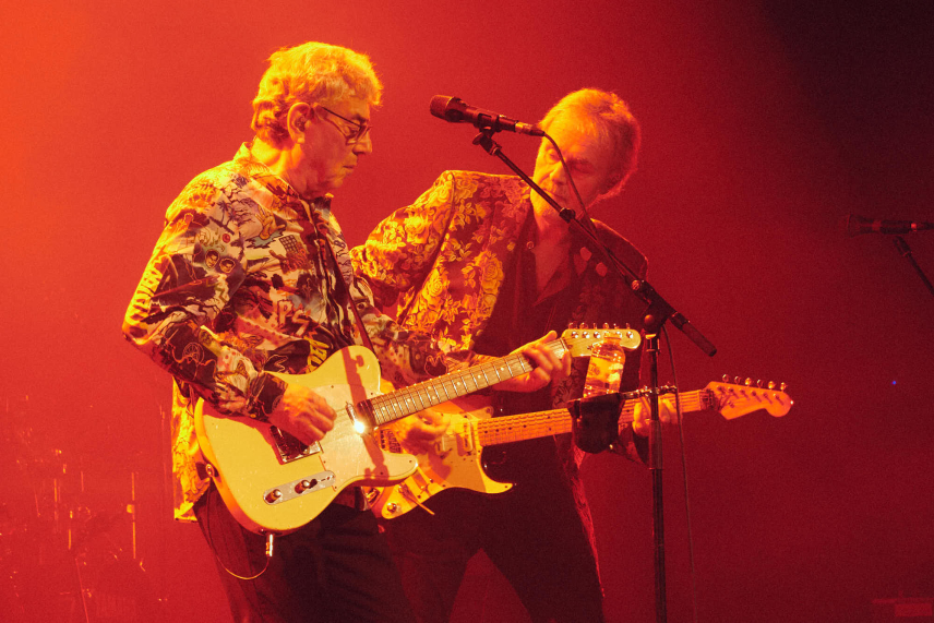 10cc live image of Graham Gouldman and Rick Fenn playing guitar under a red light taken during the live stream performance at The New Theatre, Oxford