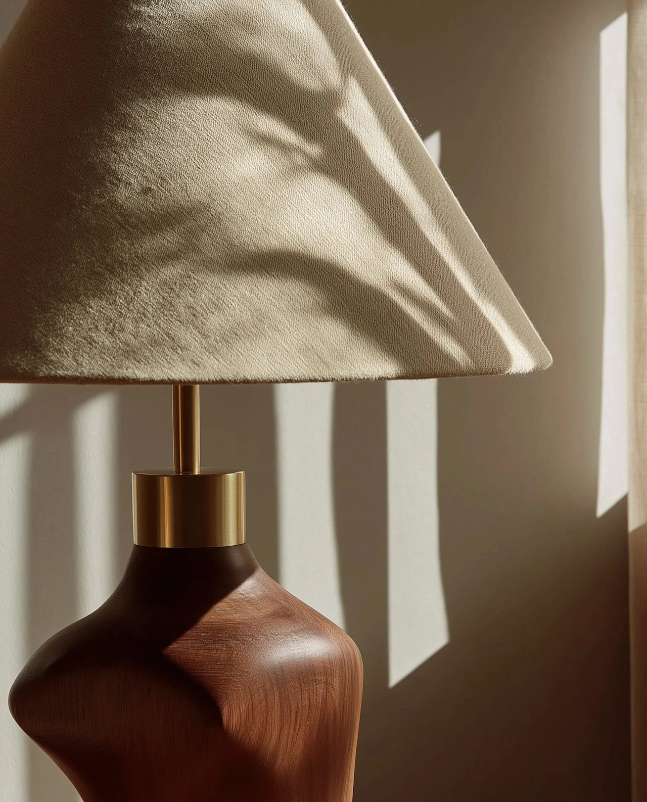 A wood-base table lamp in raking sunlight