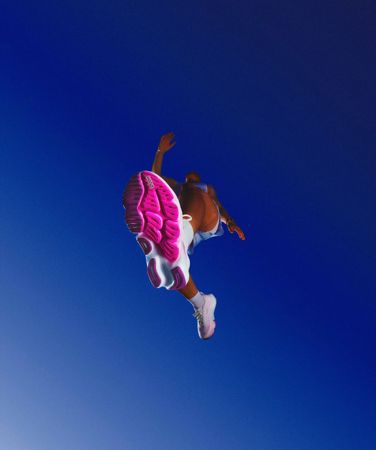 A runner mid-leap, the Glycerin outsole overhead against a blue sky