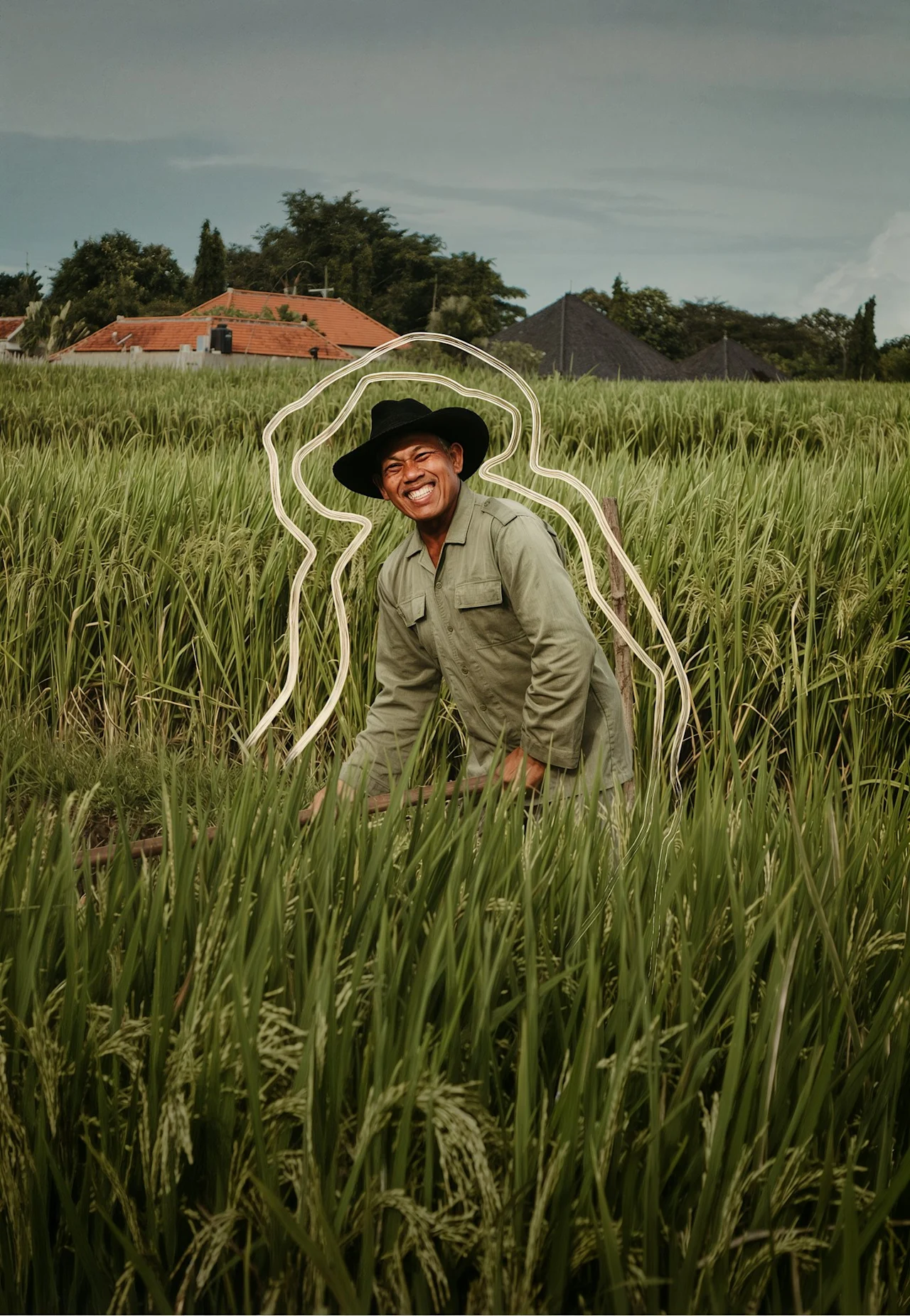 A farmer smiling in a rice field