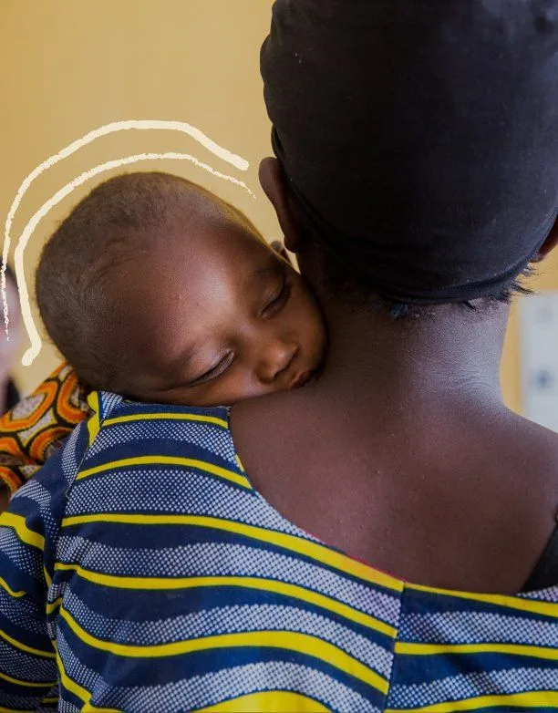 A sleeping baby carried on a parent's back