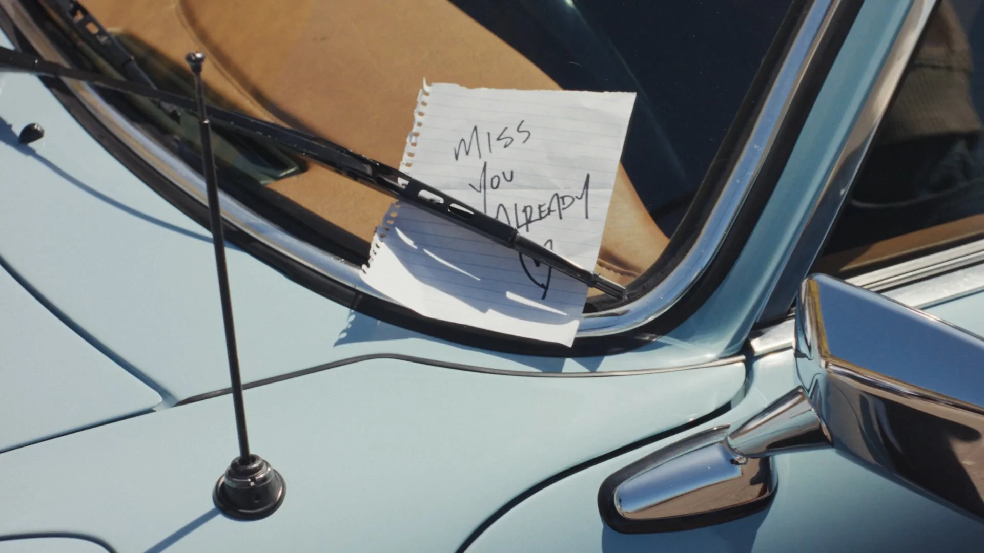 A note under a vintage windshield wiper