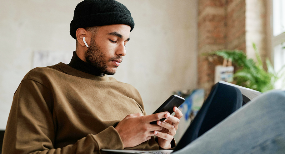 Man using his smartphone to pay a bill at his desk, illustrating flexible bill payments with Zip buy now, pay later